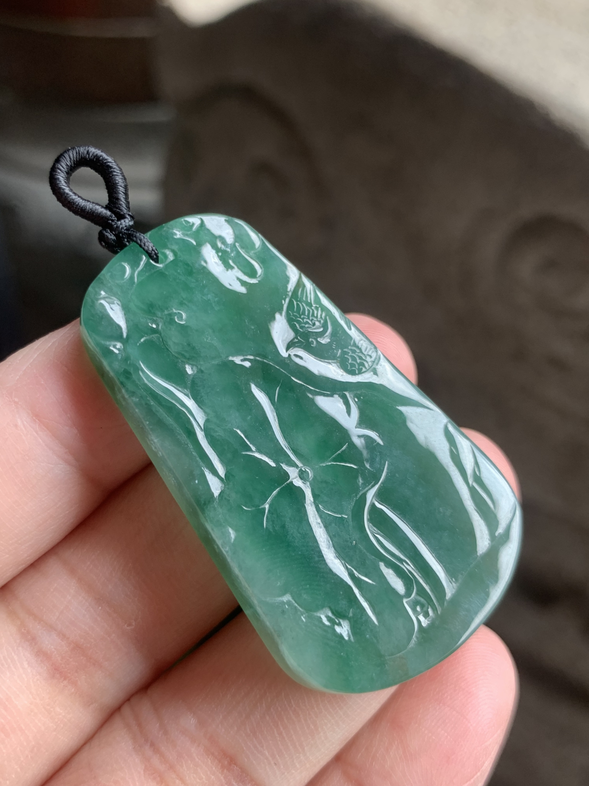 【喜上眉梢】方牌吊坠，裸石49.5*29*6 整体种色相融像把一汪春日的湖水凝进了玉里，水头足到光线下都透着清润的柔光，绿调温柔不艳俗，越看越有江南烟雨的清雅韵味。
牌面的雕工更是点睛之笔：舒展的荷叶脉络清晰，一只喜鹊停落其间，线条柔而不飘，把“荷（和）花+喜鹊（喜）”的吉祥寓意藏得含蓄又讨喜。没有繁复的堆砌，只靠流畅的雕工把“和和美美、喜事临门”的祝福揉进了玉的肌理里，日常戴不张扬，却处处透着温润贵气，无论是做日常吊坠，还是搭配中式穿搭，都能衬得人气质温婉又雅致。 不足之处在于侧边有一处表皮凹陷，无碍