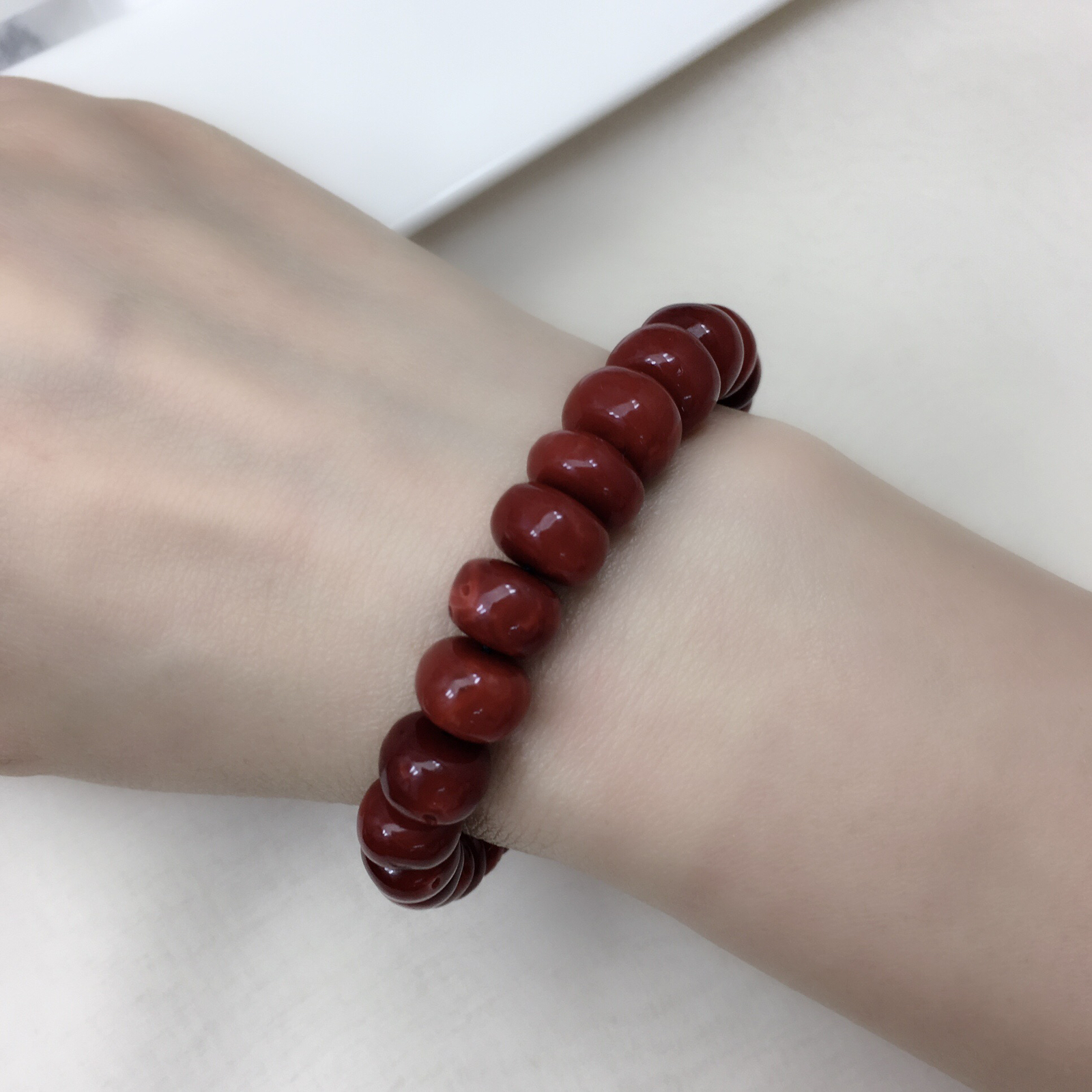 【天然日本阿卡赤血牛血红珊瑚11mm鼓珠单圈手串】天然无添加无优化，日本产地，阿卡材料、高瓷度，赤血牛血红颜色，珠子直径11-8.1mm，每颗珠子均为天然的珊瑚，珊瑚自古就为佛教珍宝，深海千年有机宝石！材料限制裸石有阿卡标志性白芯眼，收藏价值高、可传承！重量30.75克。