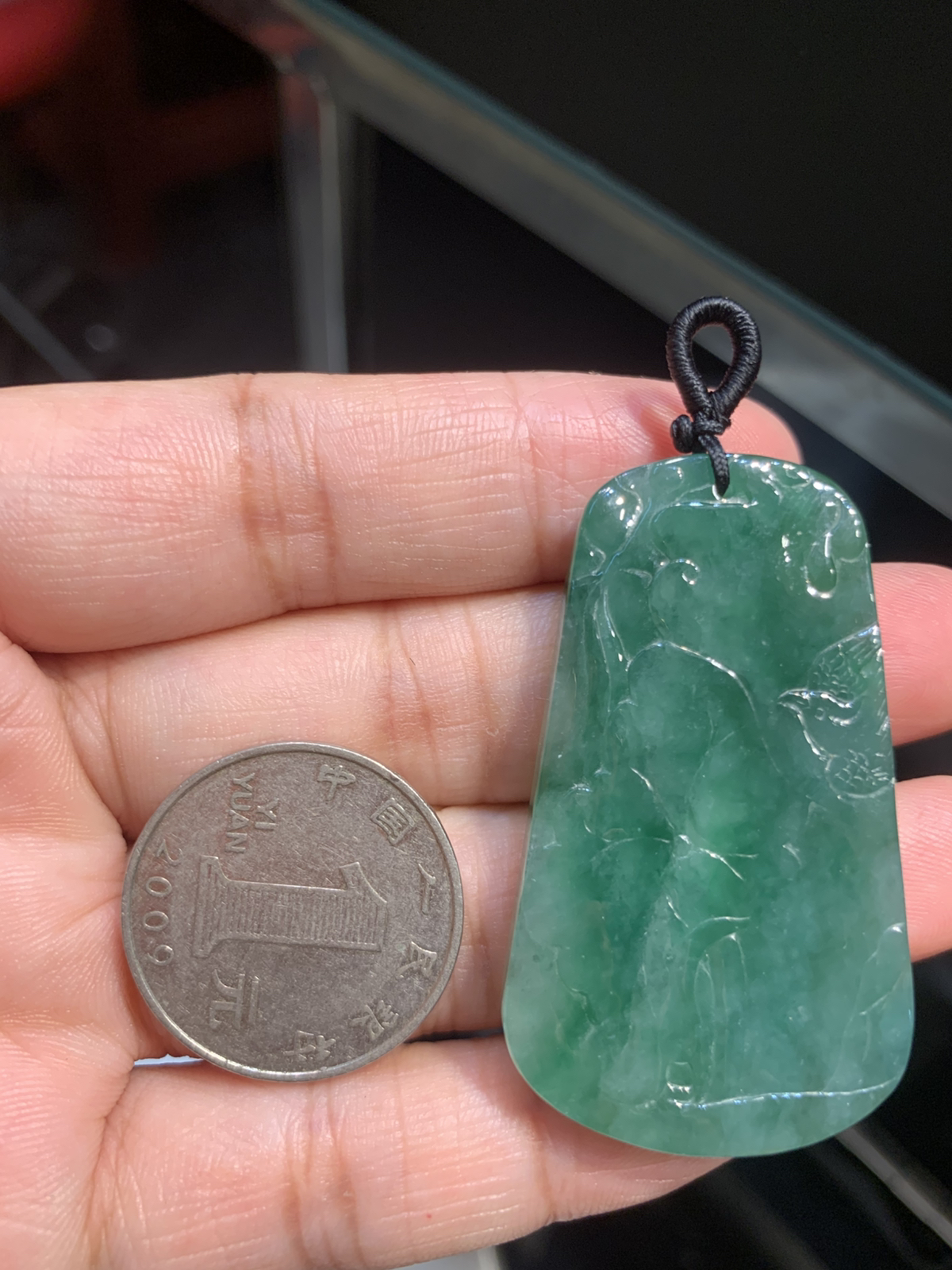 【喜上眉梢】方牌吊坠，裸石49.5*29*6 整体种色相融像把一汪春日的湖水凝进了玉里，水头足到光线下都透着清润的柔光，绿调温柔不艳俗，越看越有江南烟雨的清雅韵味。
牌面的雕工更是点睛之笔：舒展的荷叶脉络清晰，一只喜鹊停落其间，线条柔而不飘，把“荷（和）花+喜鹊（喜）”的吉祥寓意藏得含蓄又讨喜。没有繁复的堆砌，只靠流畅的雕工把“和和美美、喜事临门”的祝福揉进了玉的肌理里，日常戴不张扬，却处处透着温润贵气，无论是做日常吊坠，还是搭配中式穿搭，都能衬得人气质温婉又雅致。 不足之处在于侧边有一处表皮凹陷，无碍