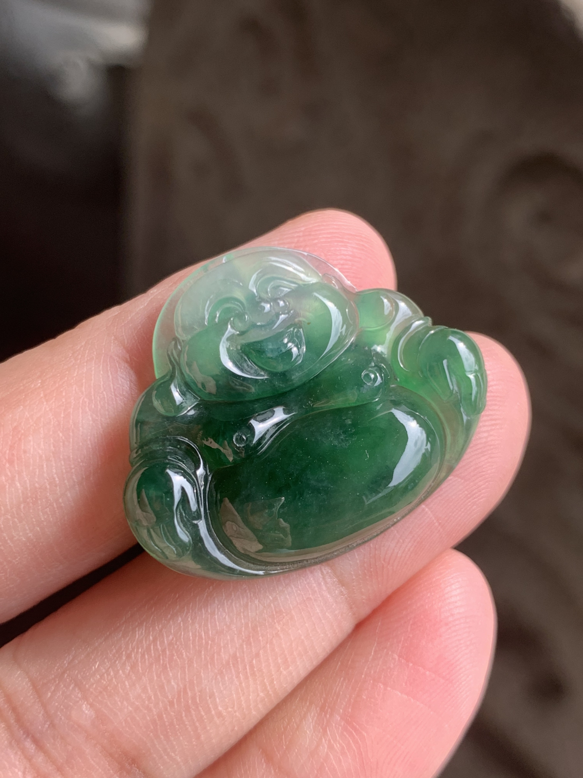 【冰油满绿佛公】吊坠，裸石尺寸24.5*30*5.2整体是冰种油绿的质地，水头足到透着柔光，玉质细腻莹润，绿调像被揉进了水光里，不艳不燥，是越看越有味道的油润质感。佛公的开脸是点睛之笔：眉眼弯弯，笑意盈盈，肚子圆润饱满，线条柔和讨喜，把“笑口常开、肚大能容”的福气都刻在了玉里。 背面右下角微表皮纹微扣