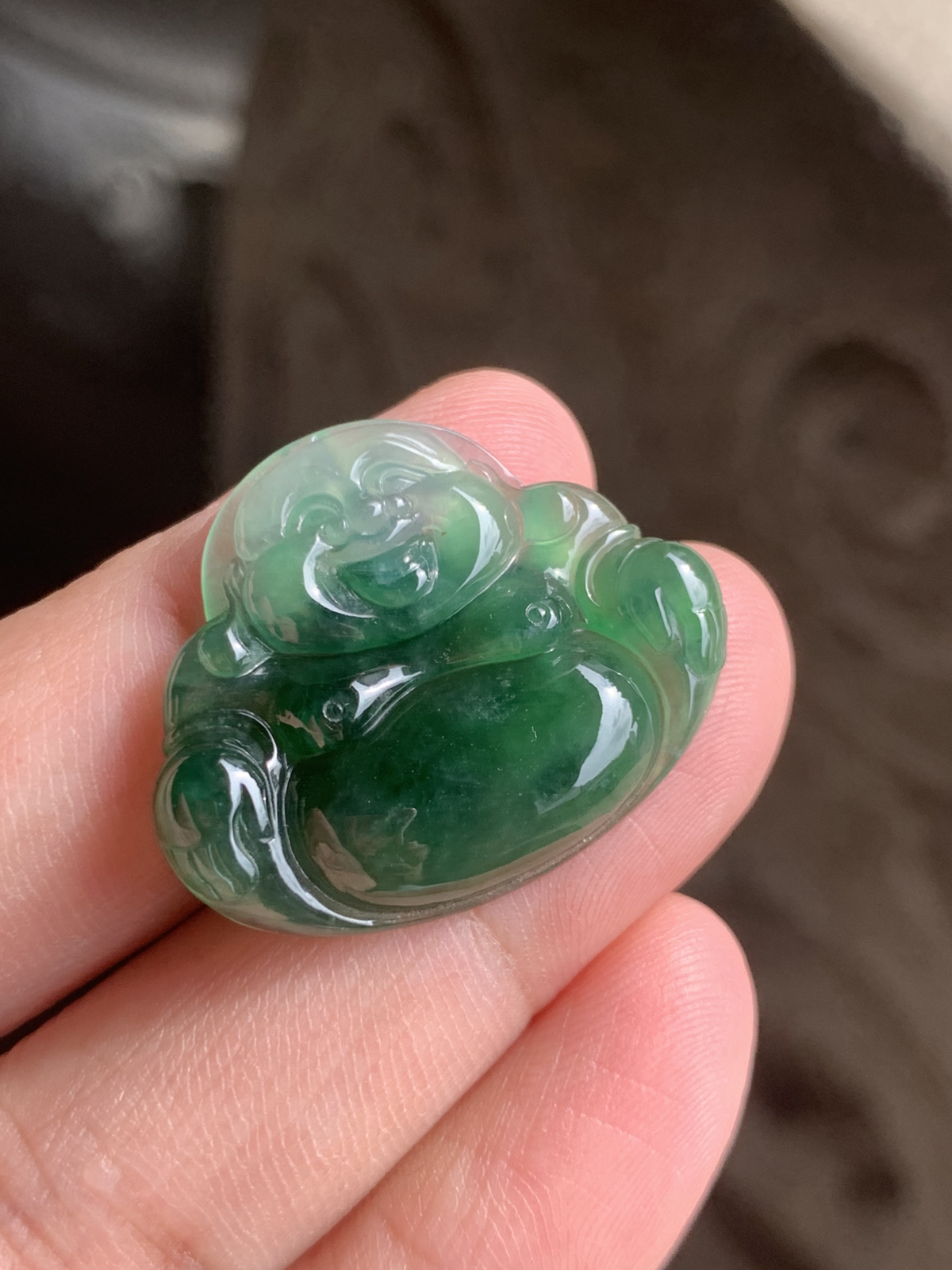 【冰油满绿佛公】吊坠，裸石尺寸24.5*30*5.2整体是冰种油绿的质地，水头足到透着柔光，玉质细腻莹润，绿调像被揉进了水光里，不艳不燥，是越看越有味道的油润质感。佛公的开脸是点睛之笔：眉眼弯弯，笑意盈盈，肚子圆润饱满，线条柔和讨喜，把“笑口常开、肚大能容”的福气都刻在了玉里。 背面右下角微表皮纹微扣