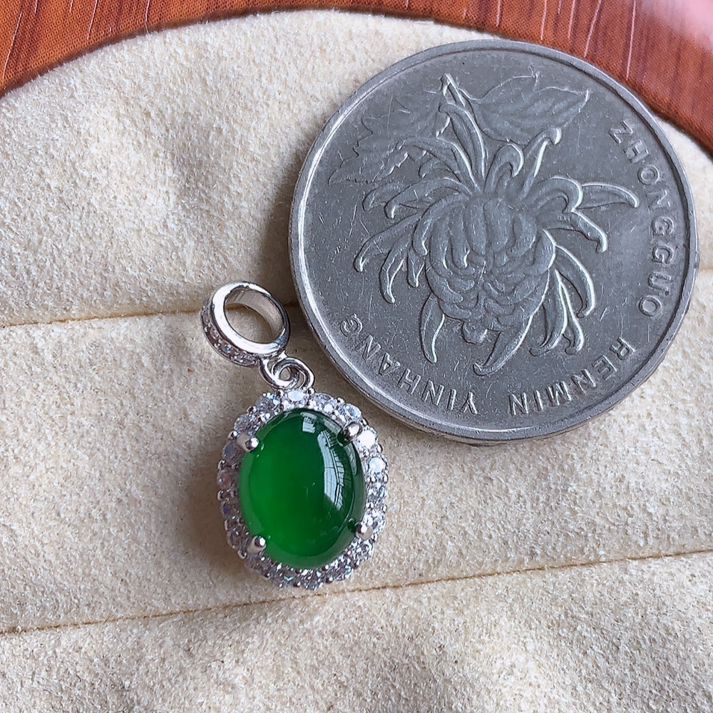 冰润飘绿蛋面翡翠吊坠，925银饰镶嵌  质地细腻，清秀高雅，饱满圆润  款式大方经典，颜色鲜艳，沁人心脾，高质量精品   W815.27  整体尺寸：20-10-7.5mm   裸石尺寸：9-7.2mm