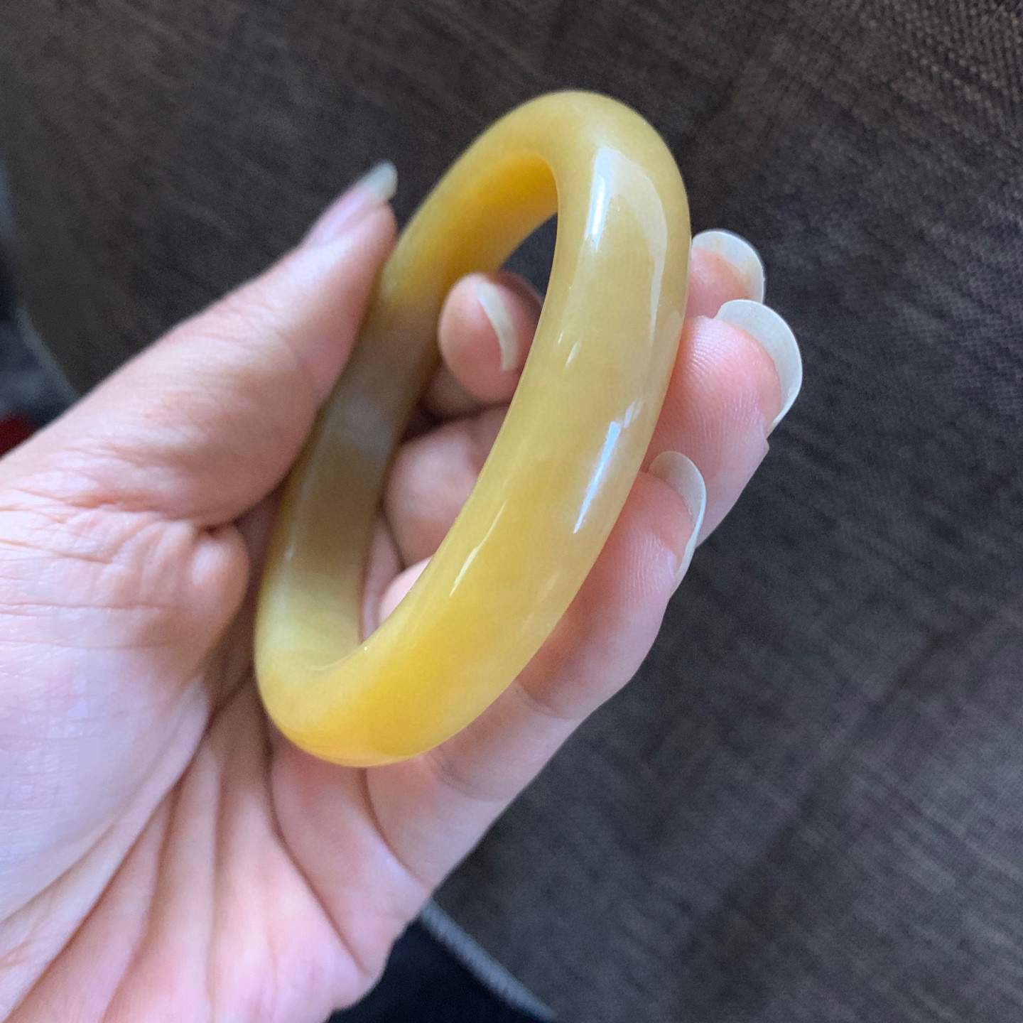 59圈口和田玉且末料全糖手镯，全蜜糖和田玉59圈口手镯，镯型古朴典雅。在诗情画意的雨巷相遇，你是我腕间的一抹风情，有你眸有深情.清风荡漾湖间静水，我愿俯身低眉，在烟波涟漪处寻