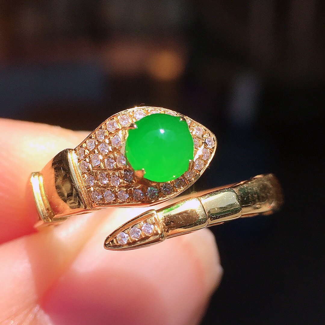 阳绿蛋面戒指，色泽均匀艳丽，玉质细腻，荧光感超
强，饱满圆润，尽显优雅气质，18k
金豪华镶嵌