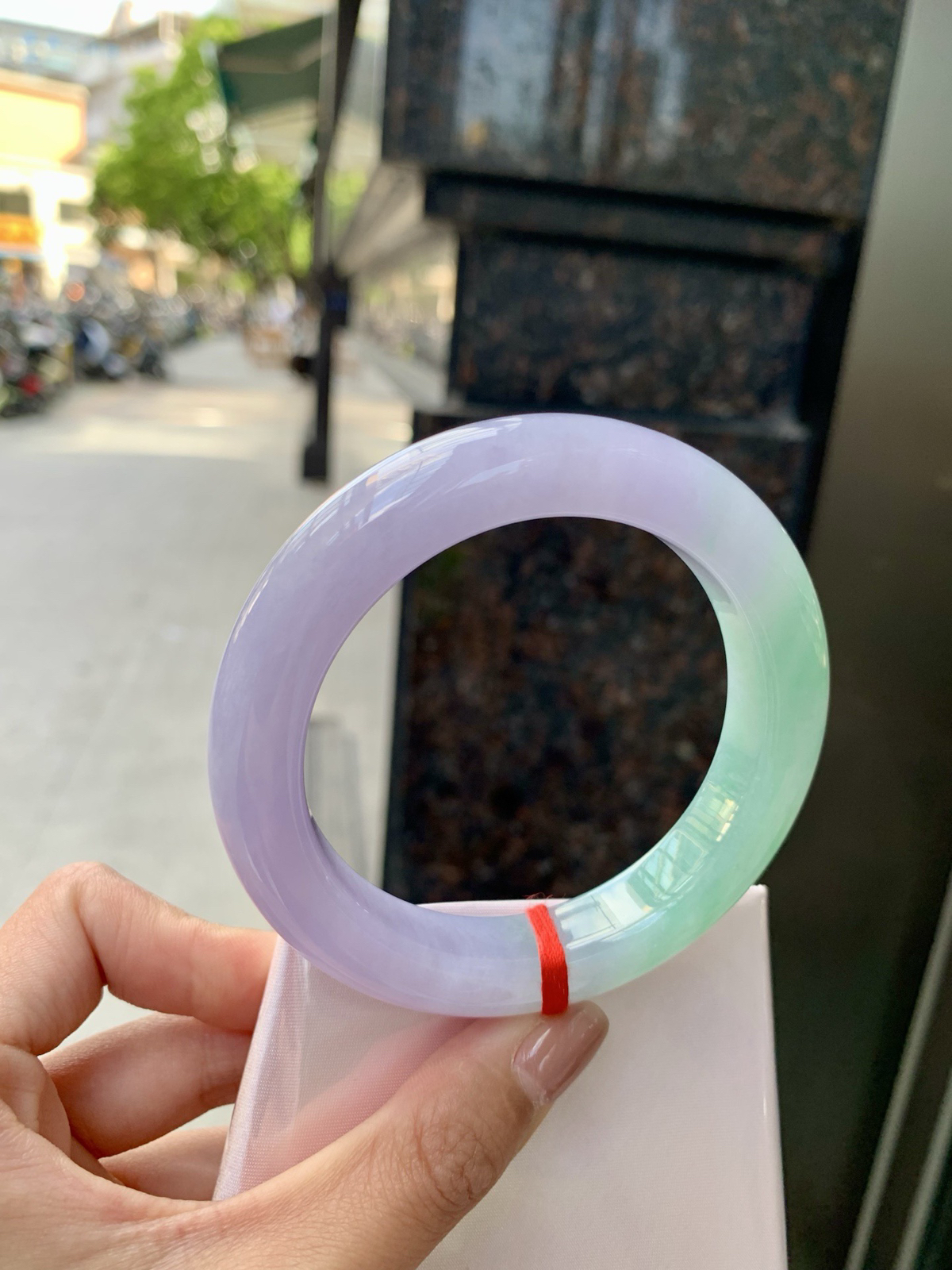 春彩正圈，腕间一段春，三分翠，七分霞。
那抹翠色，像凝住了一汪山涧水；
那片粉紫，又似揉碎了暮时云。
光一照，冰底漾起涟漪，
色根游走如墨痕化入