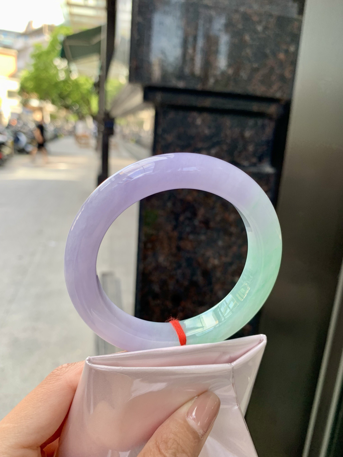 春彩正圈，腕间一段春，三分翠，七分霞。
那抹翠色，像凝住了一汪山涧水；
那片粉紫，又似揉碎了暮时云。
光一照，冰底漾起涟漪，
色根游走如墨痕化入