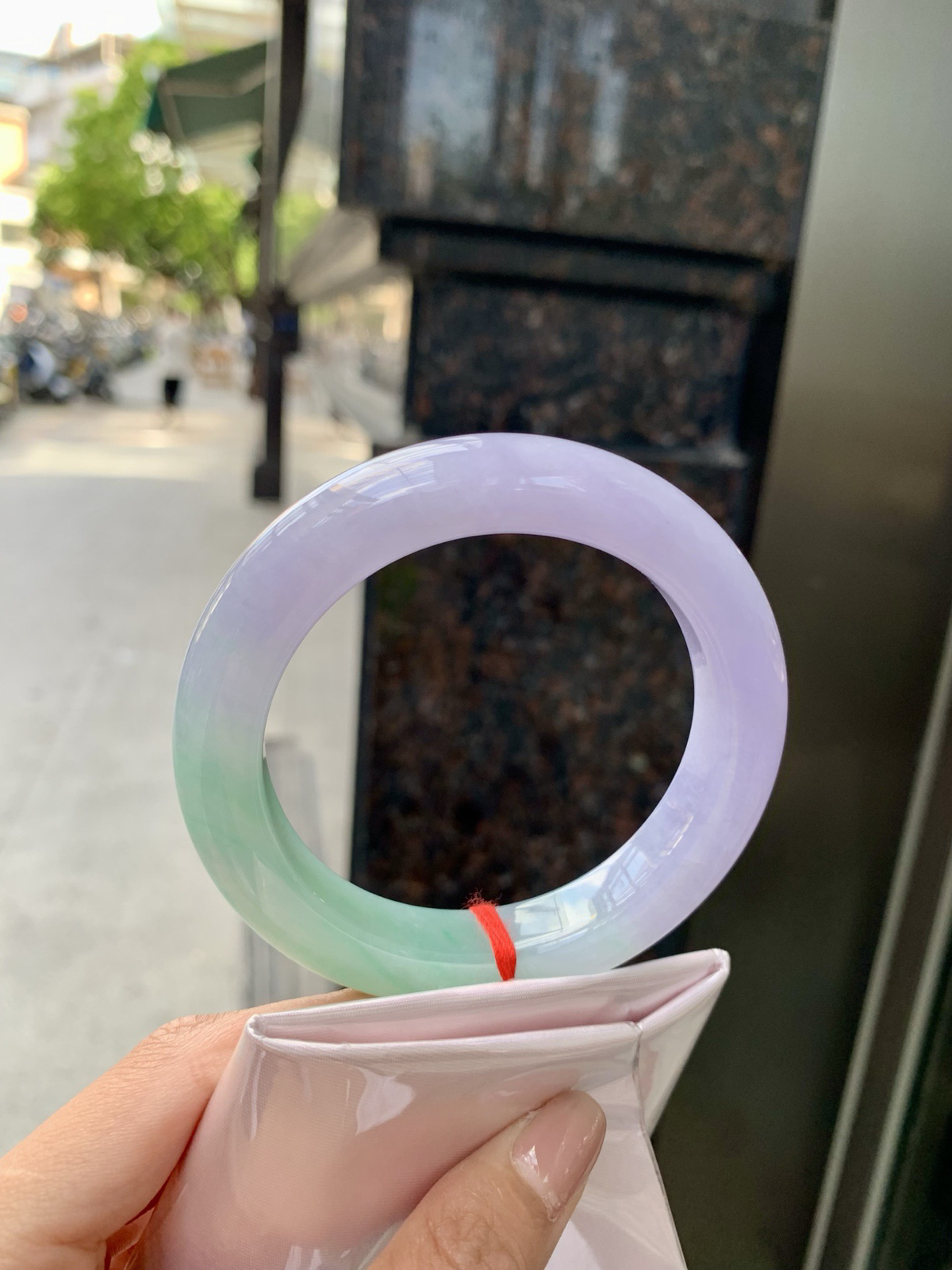春彩正圈，腕间一段春，三分翠，七分霞。
那抹翠色，像凝住了一汪山涧水；
那片粉紫，又似揉碎了暮时云。
光一照，冰底漾起涟漪，
色根游走如墨痕化入