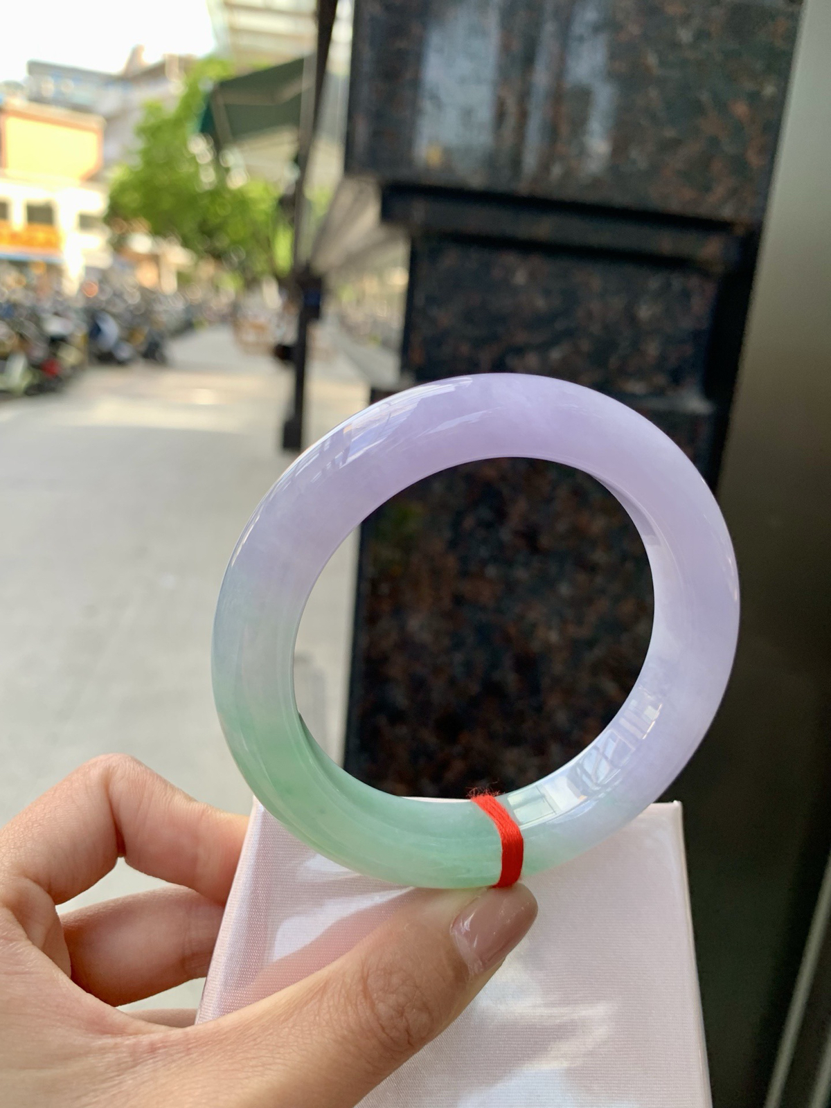 春彩正圈，腕间一段春，三分翠，七分霞。
那抹翠色，像凝住了一汪山涧水；
那片粉紫，又似揉碎了暮时云。
光一照，冰底漾起涟漪，
色根游走如墨痕化入