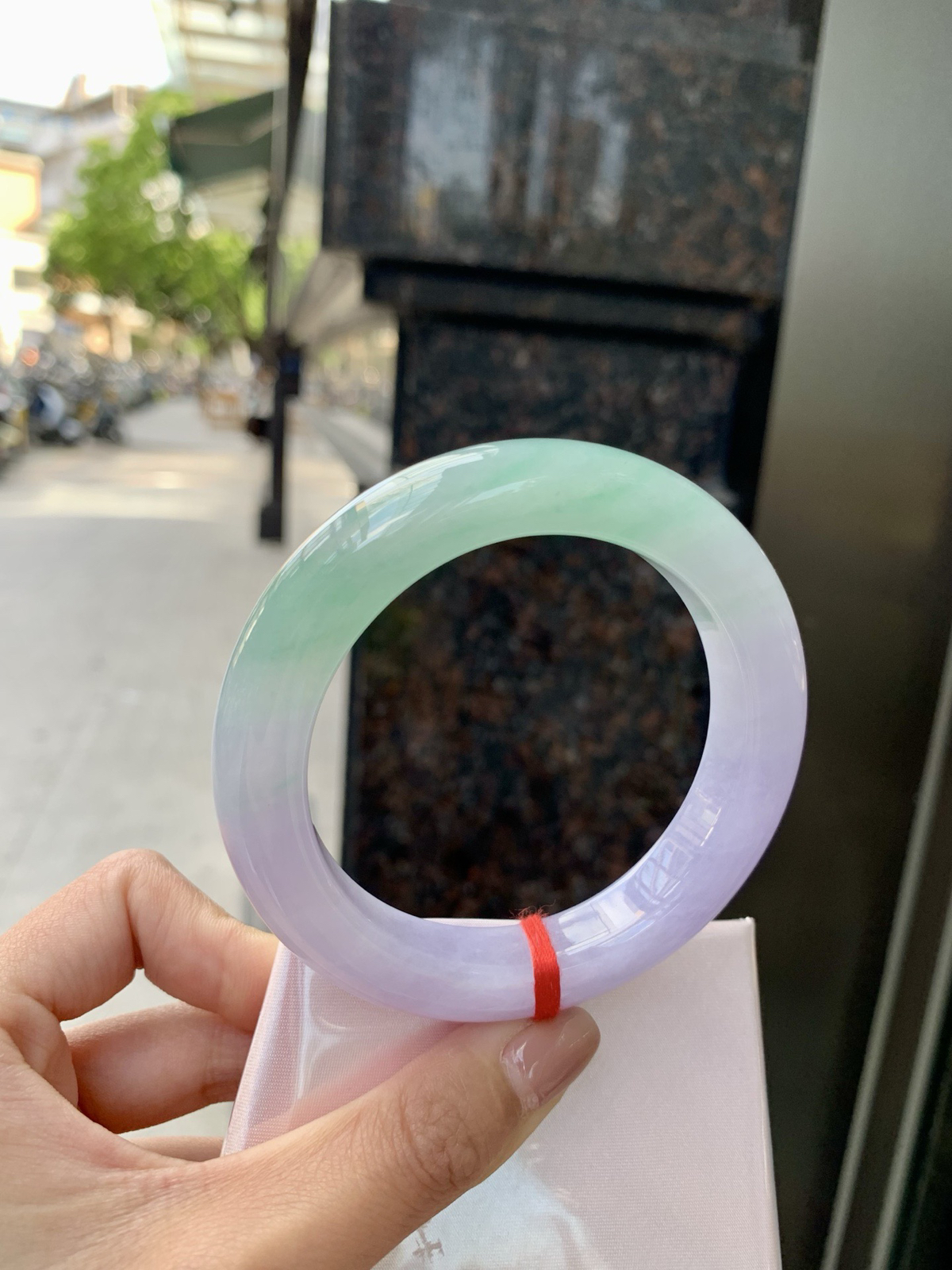 春彩正圈，腕间一段春，三分翠，七分霞。
那抹翠色，像凝住了一汪山涧水；
那片粉紫，又似揉碎了暮时云。
光一照，冰底漾起涟漪，
色根游走如墨痕化入