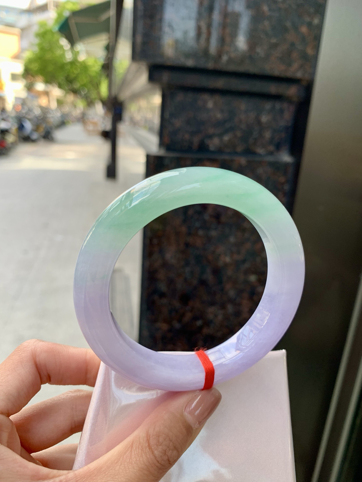 春彩正圈，腕间一段春，三分翠，七分霞。
那抹翠色，像凝住了一汪山涧水；
那片粉紫，又似揉碎了暮时云。
光一照，冰底漾起涟漪，
色根游走如墨痕化入