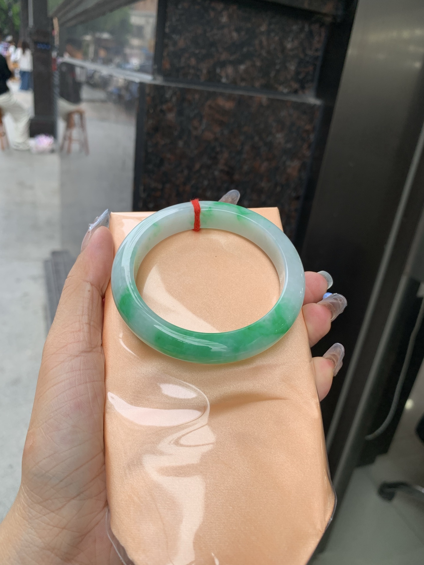 白底青正圈 57-8.4-11.6 0509-N673 打灯细纹，不影响，底妆冰润，半圈阳绿花点缀腕间风华，干净纯净的底色上，一抹翠色肆意流淌，宛如春日里的繁华盛景