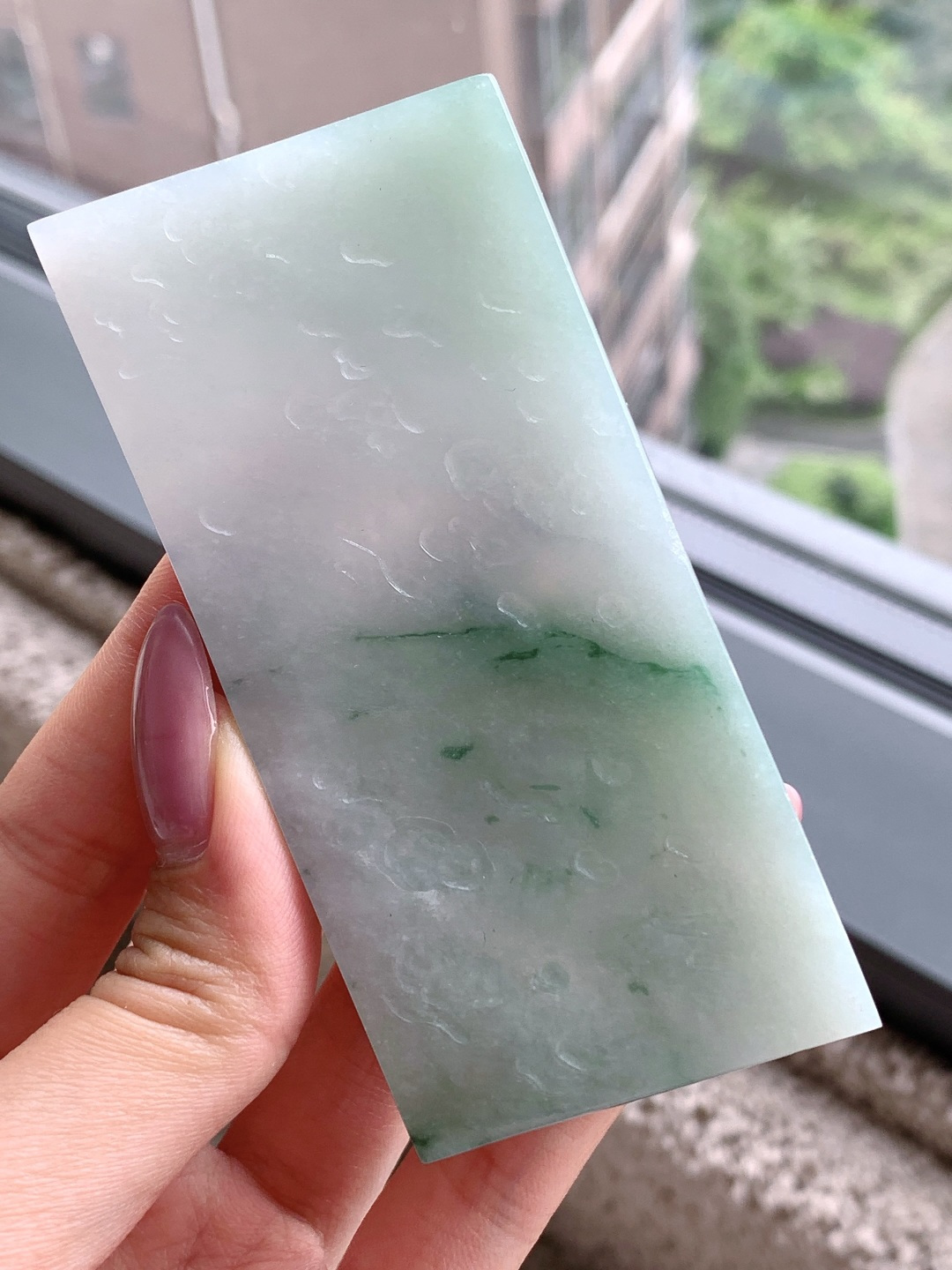 🫧 冰飘花/牌子料/片料/板料/特色料 可做牌子、人物、山水、动物、花件……等推荐参考 92.7-42.8-8.1 98.5克 材料优选 · 云横青嶂外，翠绕浅溪间。 ·这方冰种飘绿翡翠片料，如一幅晕染着淡青底色的山水小品，清润通透的玉质之上，一抹浓绿似远山如黛、似溪水含烟，在浅淡底色间舒展流淌，自带温润清和的东方气韵。它种老肉细、水头充盈，经玉雕师巧手雕琢，可化为一方层次分明的山水牌，将这份山水意境定格其间，寓意前程开阔、心境澄明；也可设计成素雅的平安无事牌，以天然飘花为点缀，尽显温润雅致的气质，象征平安顺遂、自在无忧