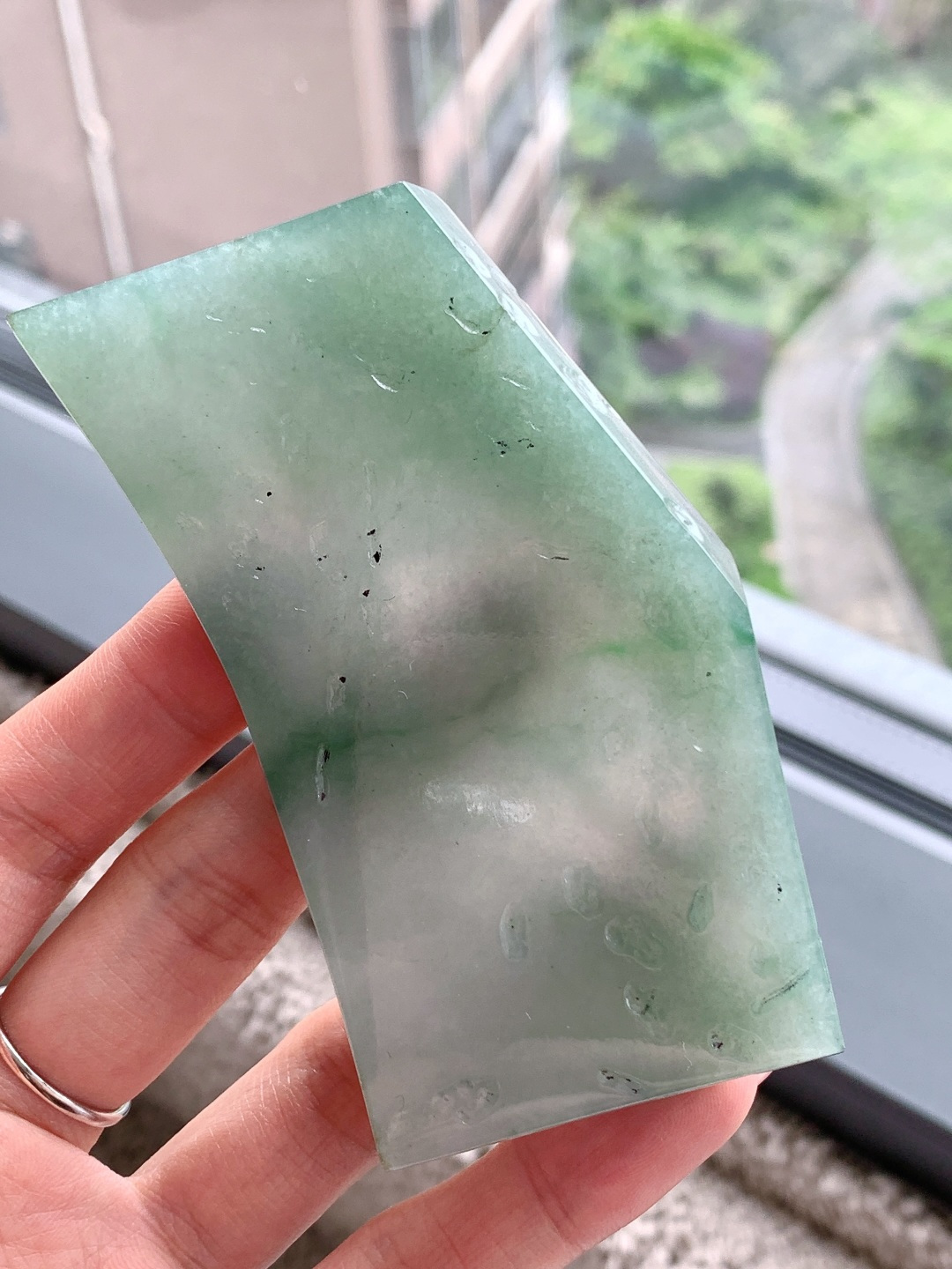 🫧 冰飘花/牌子料/片料/板料/特色料 可做牌子、人物、山水、动物、花件……等推荐参考 89-55.7-7.7 93.1克 材料优选 冰底凝清翠，飘绿映春山。 这方冰种飘绿翡翠片料，如凝住了一汪初春的山涧水，清润通透的冰底上，几缕翠色如烟似雾般晕染开来，自带朦胧柔美的江南气韵。它种老肉细、水头充盈，经玉雕师巧手雕琢，可化为一幅清雅的山水牌，将这份春日生机定格其间，寓意母亲如青山般安稳，如绿水般温柔，庇佑她岁岁无忧、心境澄明；也可化作一枚平安无事牌，以素面呈现这份天然之美，象征着岁月静好，愿她余生皆安，喜乐常伴。
