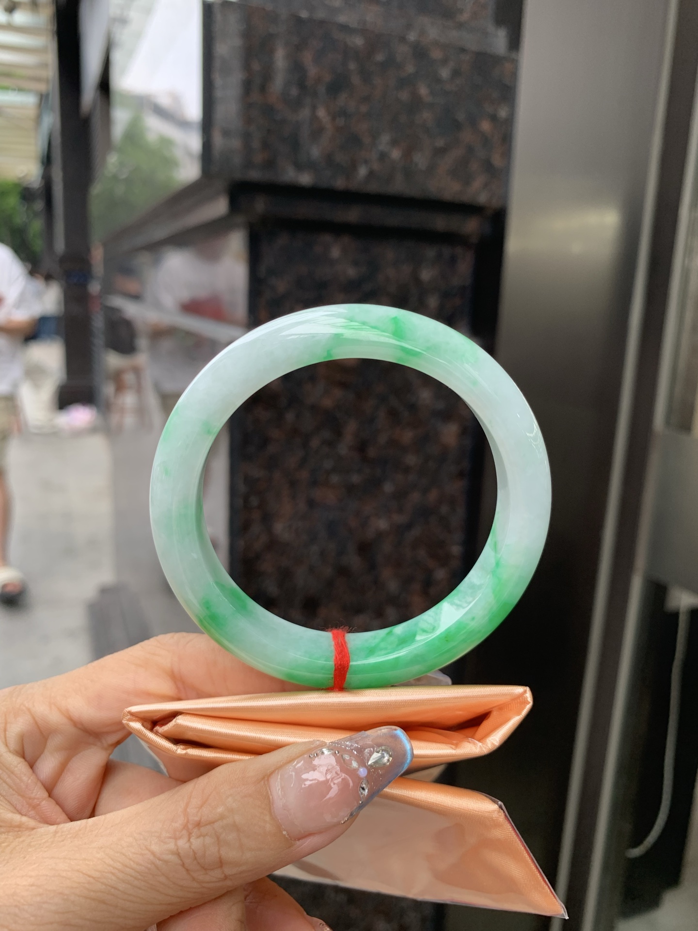 白底青正圈 57-8.4-11.6 0509-N673 打灯细纹，不影响，底妆冰润，半圈阳绿花点缀腕间风华，干净纯净的底色上，一抹翠色肆意流淌，宛如春日里的繁华盛景