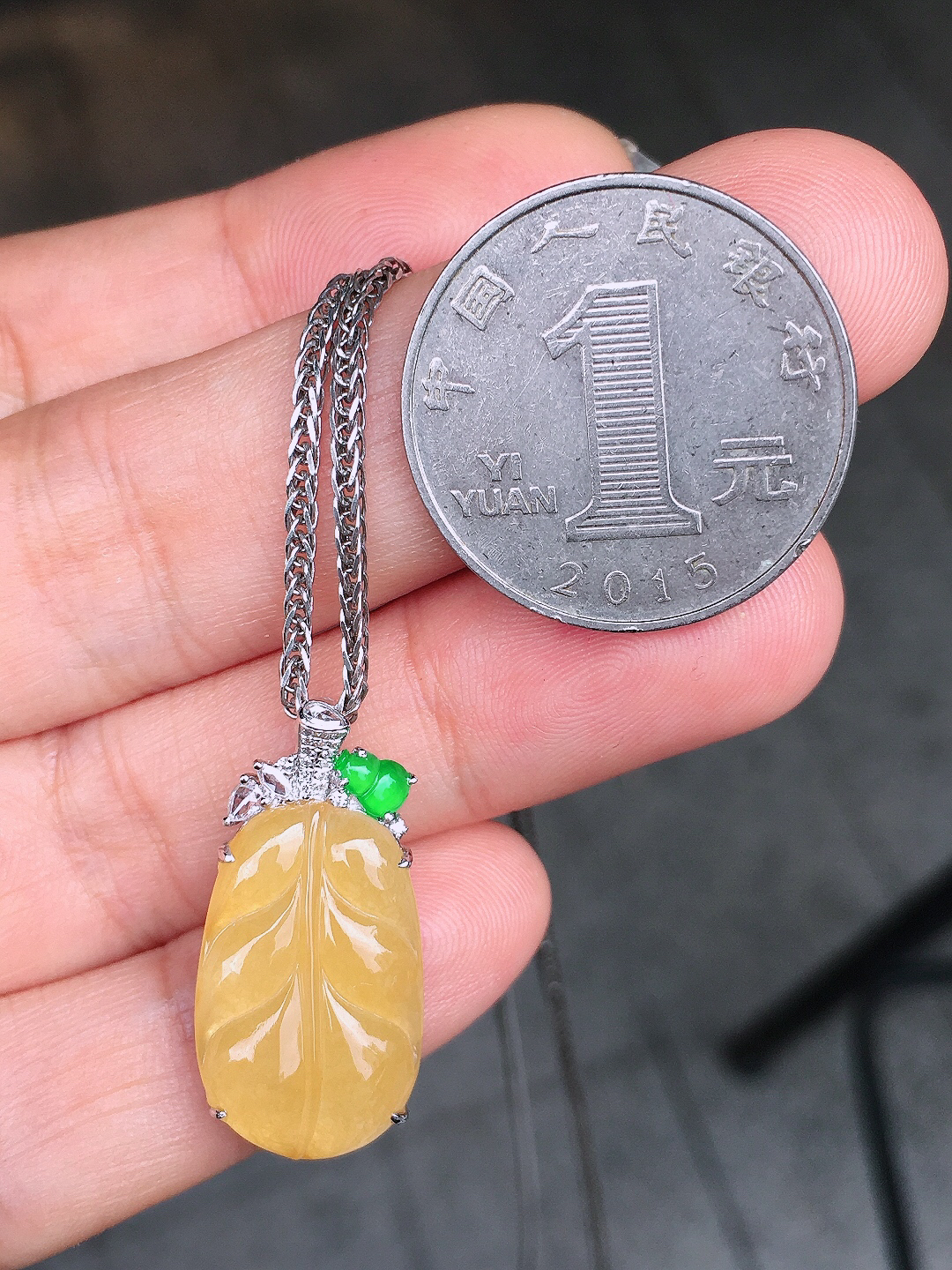 黄翡玉叶吊坠，色泽均匀艳丽，玉质细腻，荧光感超
强，饱满圆润，简单大方，尽显优雅气质，18k
金豪华镶嵌