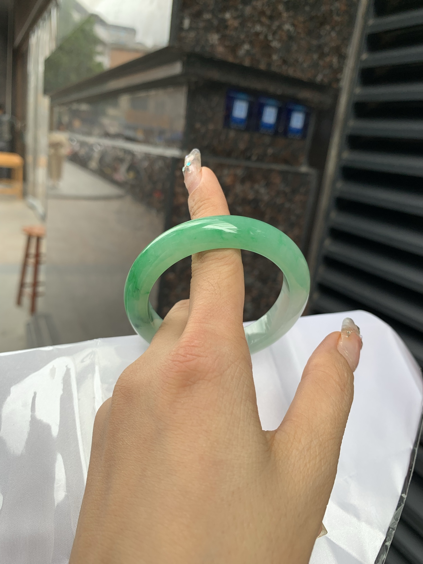 阳绿白底青正圈 打灯细纹，底妆冰润，近满圈阳绿点缀腕间风华，干净纯净的底色上，一抹翠色肆意流淌，宛如春日里的繁华盛景