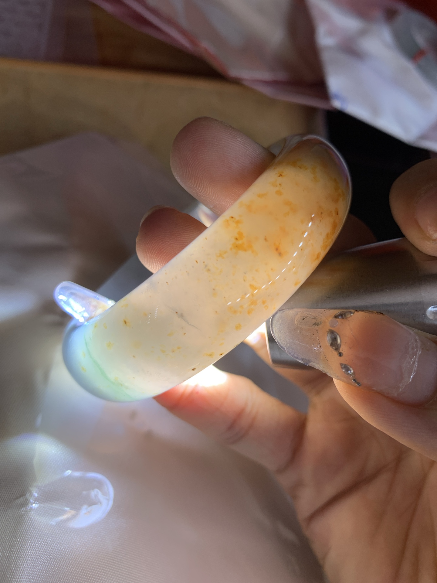 三彩洒金宽版正圈，打灯细纹，底妆冰润细腻，玉见三彩，镯藏星河，细腻的底妆里，晕染着温柔的淡紫底色，几抹绿花悄悄探头，再配上满天洒下的金桂花，像把春日的晚晴，夏夜的星光，都揉进这一圈圆满里。