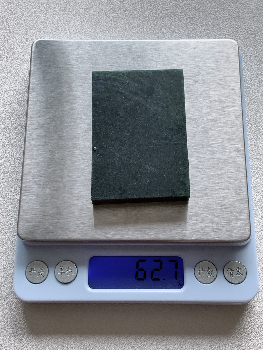 墨翠/牌子料/片料/板料/特色料 可做牌子、人物、山水、动物、花件……等推荐参考 尺寸61.7-42-7.3 重量62.7克 材料优选 墨染千山色，光凝一鉴秋。 凝润墨翠自带沉敛光泽，似水墨晕染的山河画卷，自带苍劲雅致的氛围感，可雕琢成山水或瑞兽题材，借玉中浓墨质感传递沉稳气场，寓意前程似锦、纳福；也可做简约素牌，尽显低调感，寄托平安无事、圆融一生的祈愿。