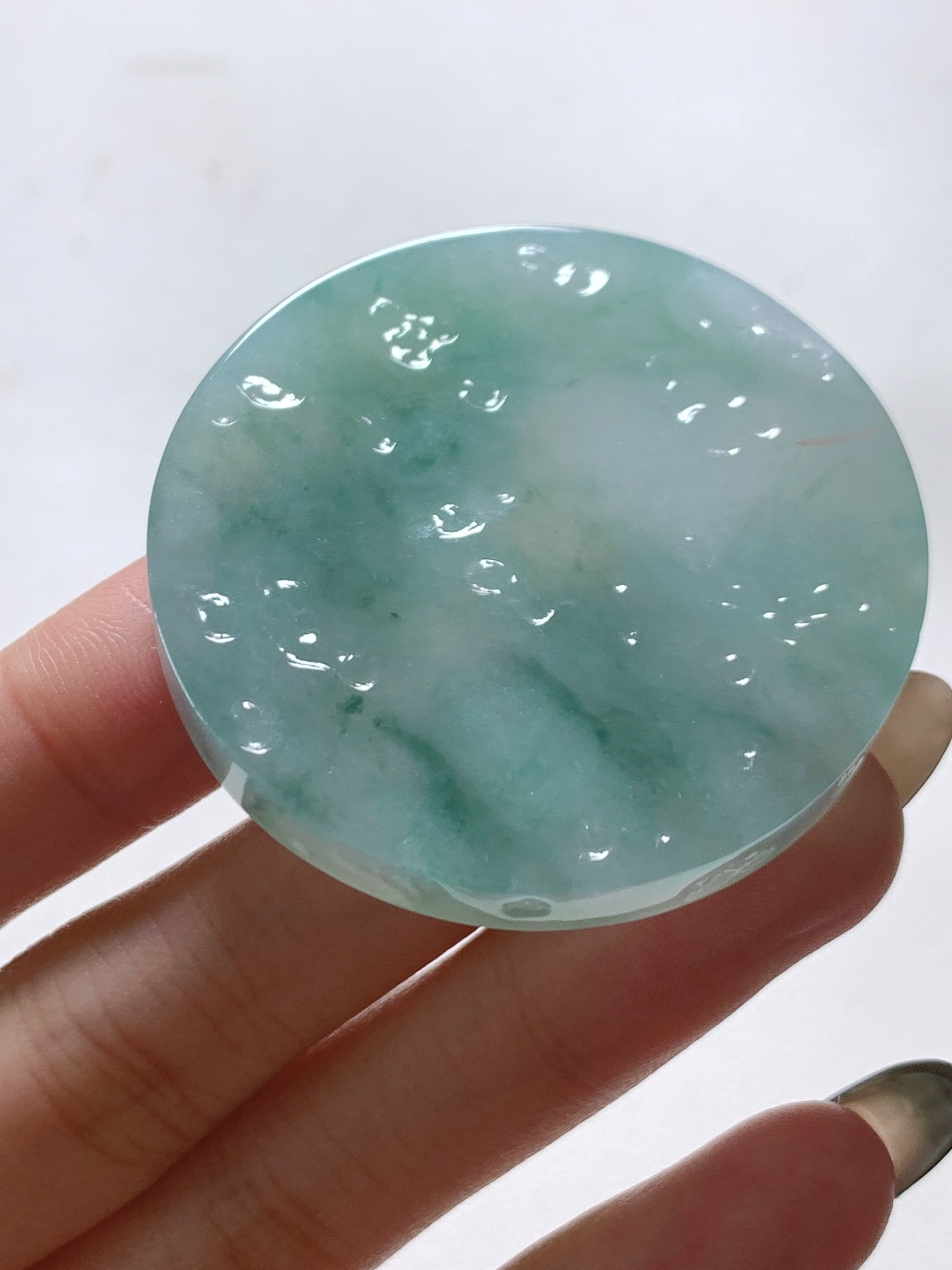 【材料】🫧 冰飘花/牌子料/镯心料/特色料 【题材】可做牌子、人物、山水、动物、花件……等推荐参考 【尺寸】48.4-7.3 【重量】43.9克 材料优选 · 云栖晴水凝清碧，风染浮花映玉圆。 ·冰糯种飘花翡翠圆牌料，质地莹润胶感透亮，晴水底色清透如溪，飘花如流云漫卷、似远山含黛，晕染出雨后初晴的空灵意境，可雕刻无事圆牌、山水牌或云纹题材，寓意圆满顺遂、清雅安然，佩戴间尽显温润内敛的东方气韵。