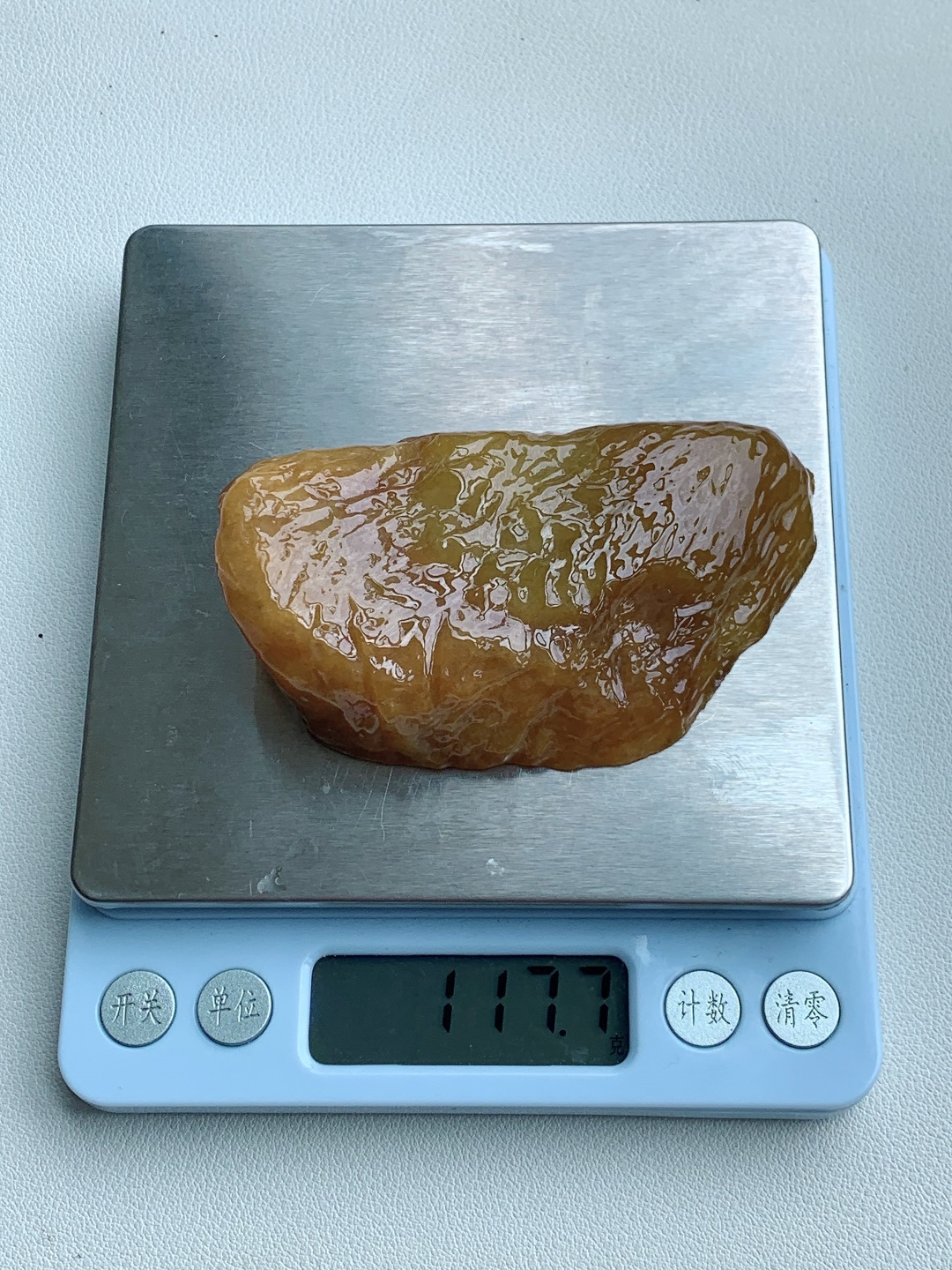 【材料】🫧冰黄翡 /牌子料/立体料/特色料【题材】可做把玩件、牌子、人物、山水、动物、花件……等推荐参考【尺寸】79.1-47.2-21【重量】117.7克· 凝脂熔金藏暖韵，原石璞玉蕴福祥。·满料黄翡原石通体裹蜜润暖黄，玉质油亮凝润、肌理自然起伏，满圈色泽匀润浓郁，可随形打磨金福原石挂坠，黄翡寓意金玉满堂、招财纳福，浑然天成的暖调自带温润华贵的质感，佩戴聚财显雍容，收藏兼具雅致与升值底蕴。