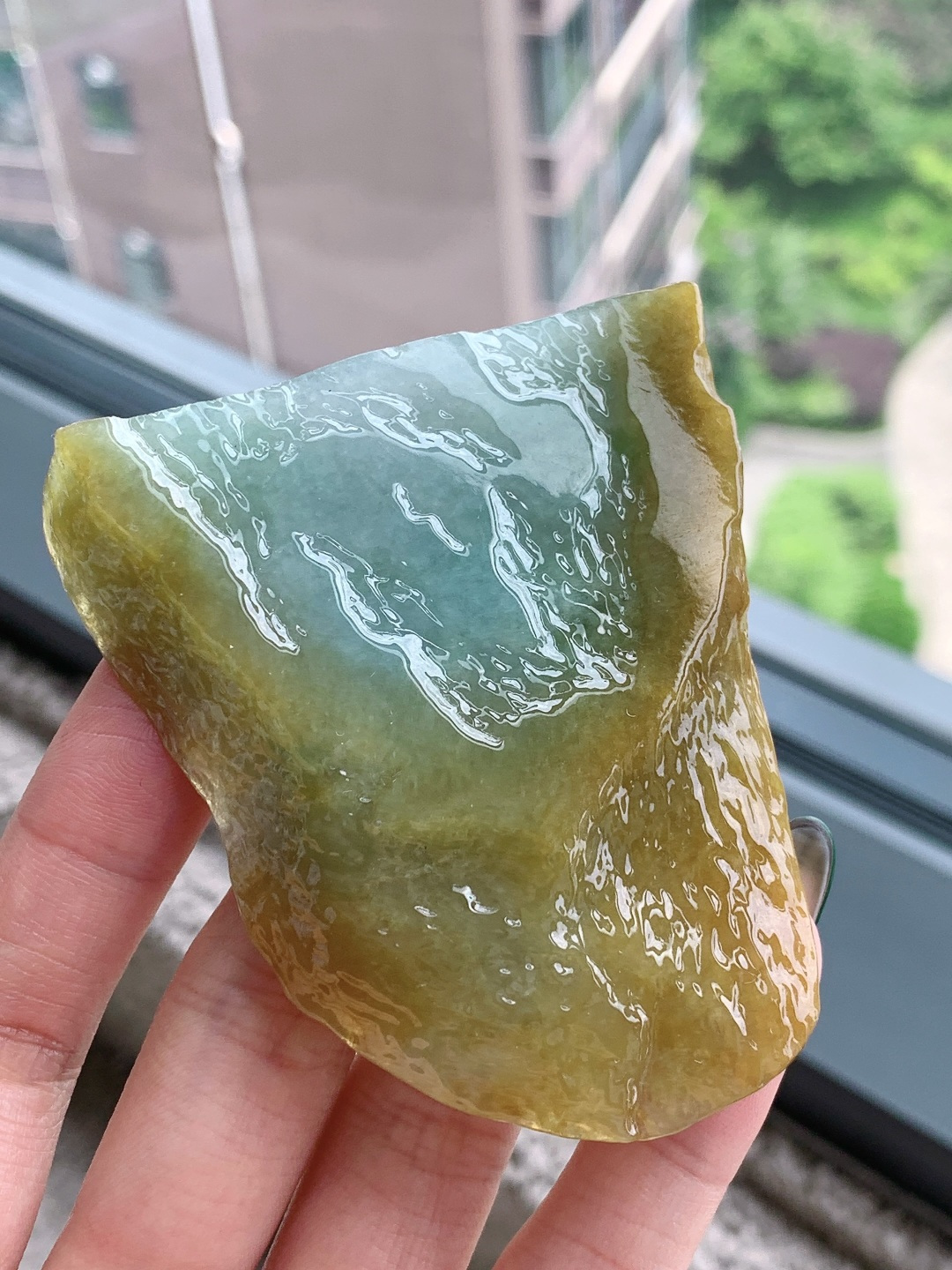 【材料】🫧 冰黄加绿/牌子料/片料/板料/特色料【题材】可做牌子、人物、山水、动物、花件……等推荐参考【尺寸】71.9-64.1-8.6【重量】81.1克· 黄皮围翠藏秋韵，碧水凝莹蕴玉灵。·天然黄加绿翡翠原石，外圈暖黄翡皮裹着内里清润湖绿，玉质水润通透、肌理莹亮，俏色层次浑然天成，可巧雕山水随形牌，借黄皮雕琢峻岭、翠色勾勒溪泉，山水题材寓意坐拥福禄、山水纳祥，天然原石自带山野悠然意境，雕琢后古朴雅致，佩戴收藏皆宜。