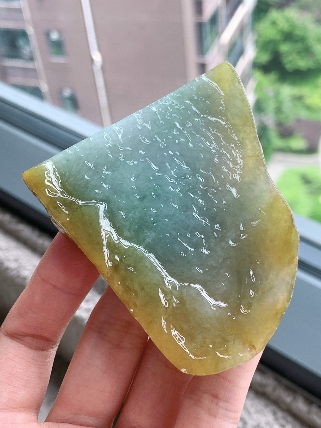 【材料】🫧 冰黄加绿/牌子料/片料/板料/特色料【题材】可做牌子、人物、山水、动物、花件……等推荐参考【尺寸】71.9-64.1-8.6【重量】81.1克· 黄皮围翠藏秋韵，碧水凝莹蕴玉灵。·天然黄加绿翡翠原石，外圈暖黄翡皮裹着内里清润湖绿，玉质水润通透、肌理莹亮，俏色层次浑然天成，可巧雕山水随形牌，借黄皮雕琢峻岭、翠色勾勒溪泉，山水题材寓意坐拥福禄、山水纳祥，天然原石自带山野悠然意境，雕琢后古朴雅致，佩戴收藏皆宜。