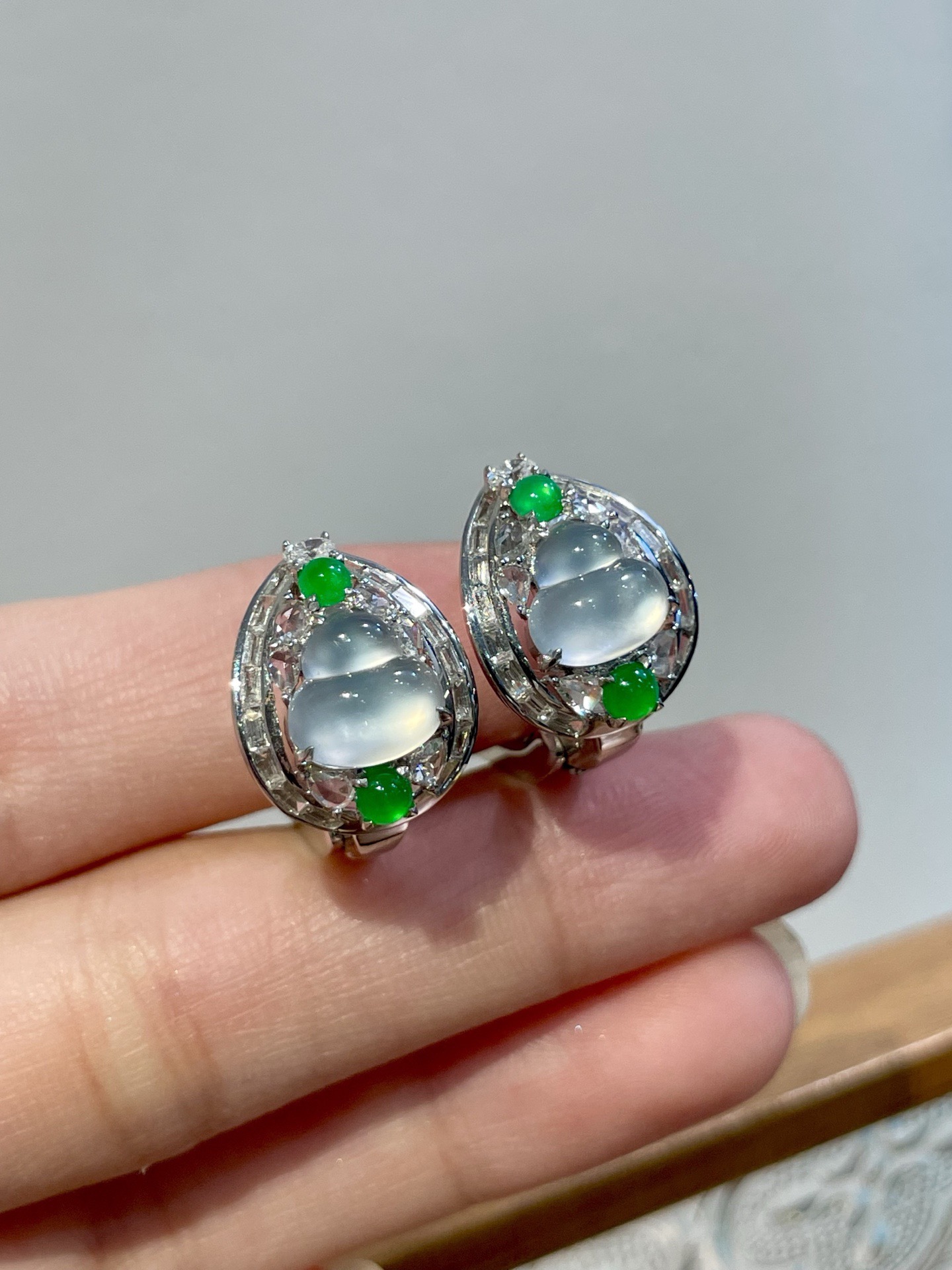 18k玻璃种葫芦耳扣 作为耳扣，佩戴感同样贴心：耳扣开合处暗藏弹簧设计，轻按即可扣合，走动或转头时，葫芦会随动作微微晃动，玻璃种的冷光便在耳畔流转，似有“福禄随身”的灵动感，却无多余声响，安静又吸睛 尺寸：16.4*12.5*17.1 裸石：7.5*7.7*3.2