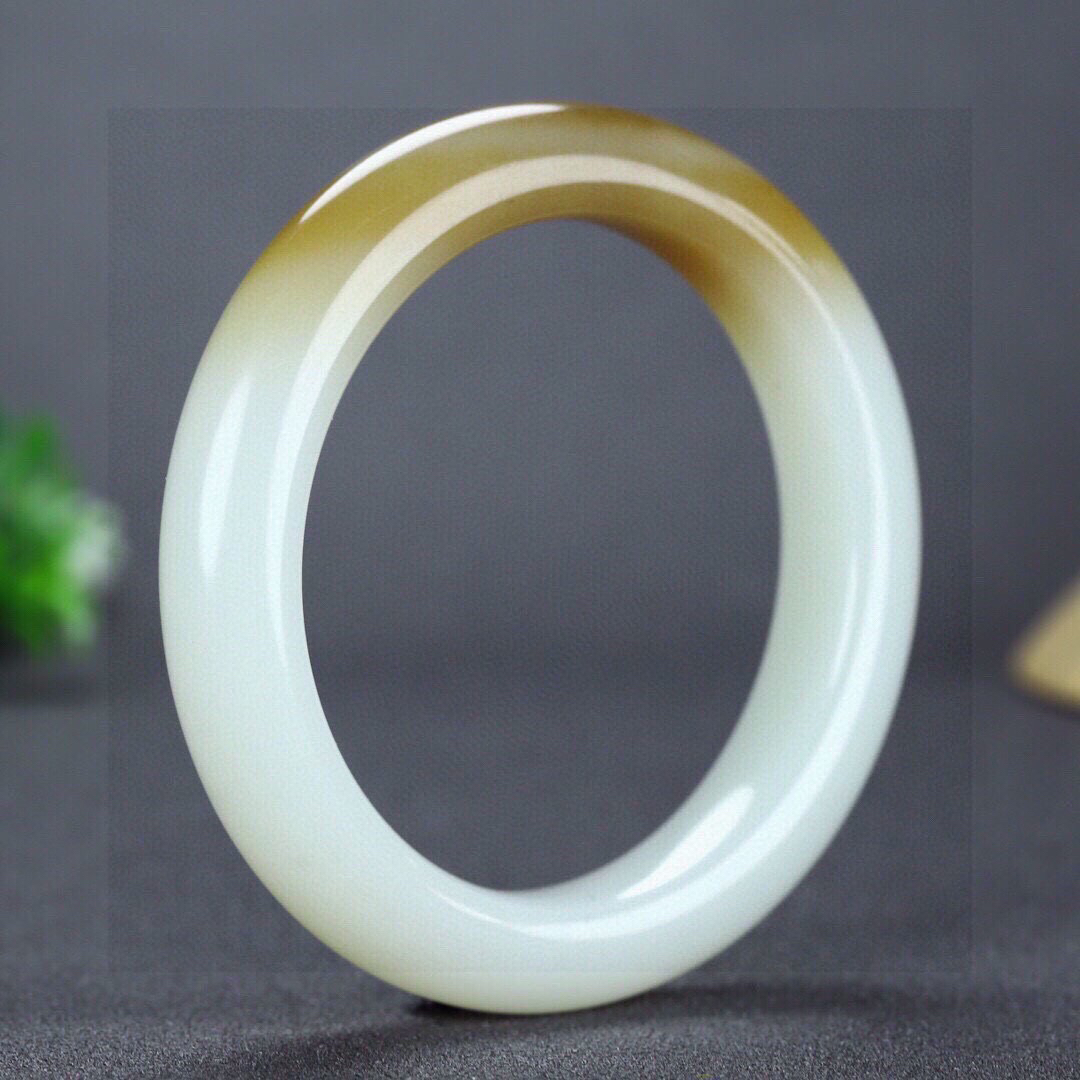 圈口：55.5重量：60.65g 尺寸：12.0/10，新疆和田玉羊脂玉且末糖玉手镯  颜色纯正 泥鳅背 每个女人都应该拥有一只属于自己的手镯 让他贴近您的心灵 触摸你的心跳 感知你的情意 经过你的手 必定会留下生命的烙印 有啦手镯的装点 女人便是一道迷人的风景 宁静 典雅 秀外慧中