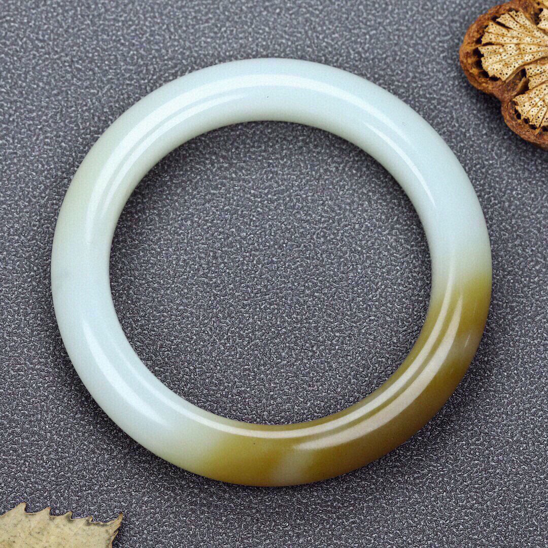 圈口：55.5重量：60.65g 尺寸：12.0/10，新疆和田玉羊脂玉且末糖玉手镯  颜色纯正 泥鳅背 每个女人都应该拥有一只属于自己的手镯 让他贴近您的心灵 触摸你的心跳 感知你的情意 经过你的手 必定会留下生命的烙印 有啦手镯的装点 女人便是一道迷人的风景 宁静 典雅 秀外慧中