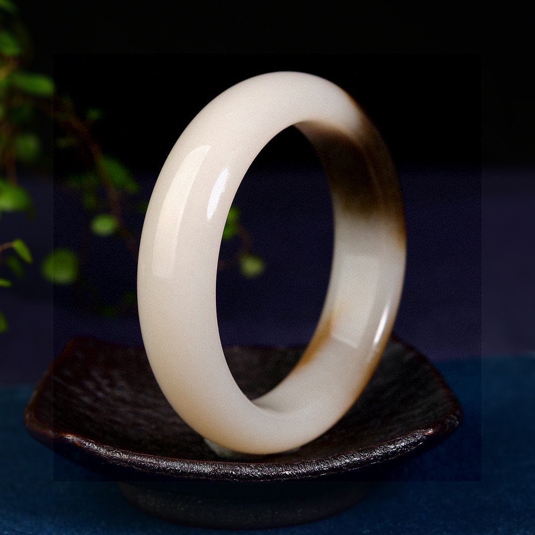 圈口: 60 重量：94.50g 规格：  18.0/10.2精品 和田玉黑皮糖色 藕粉底，三色为宝，非常特别 小时候就听长辈讲过四个手镯的故事 ：第一个手镯是我们来到这个世界的时候 父母给我们的见面礼；第二个手镯是我们成年以后会挣钱的时候  送给自己的成长礼；第三个手镯是我们结婚的时候伴侣之间互赠的定情信物；第四个手镯是多年以后我们传承给子女的传家宝。而他们四个都离不开两个词语：一个亲情 ，一个陪伴！