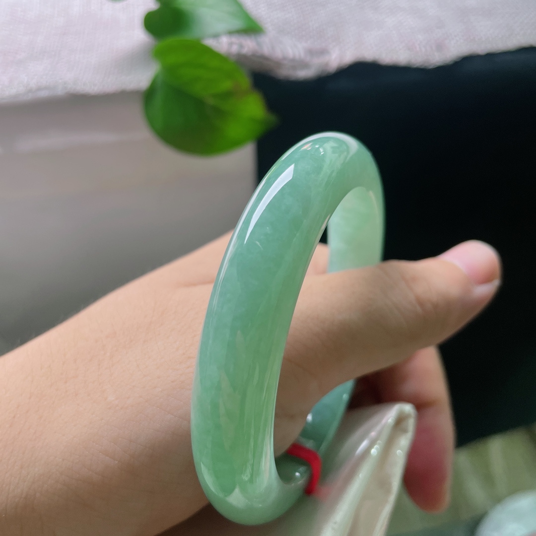 55/11.8/9.4，满绿正圈，翠色满裹镯身，玉质通透水润，细腻种质漾着温润水光，腕间一戴，便是清浅舒缓的东方温柔。无裂，-ss55040a
