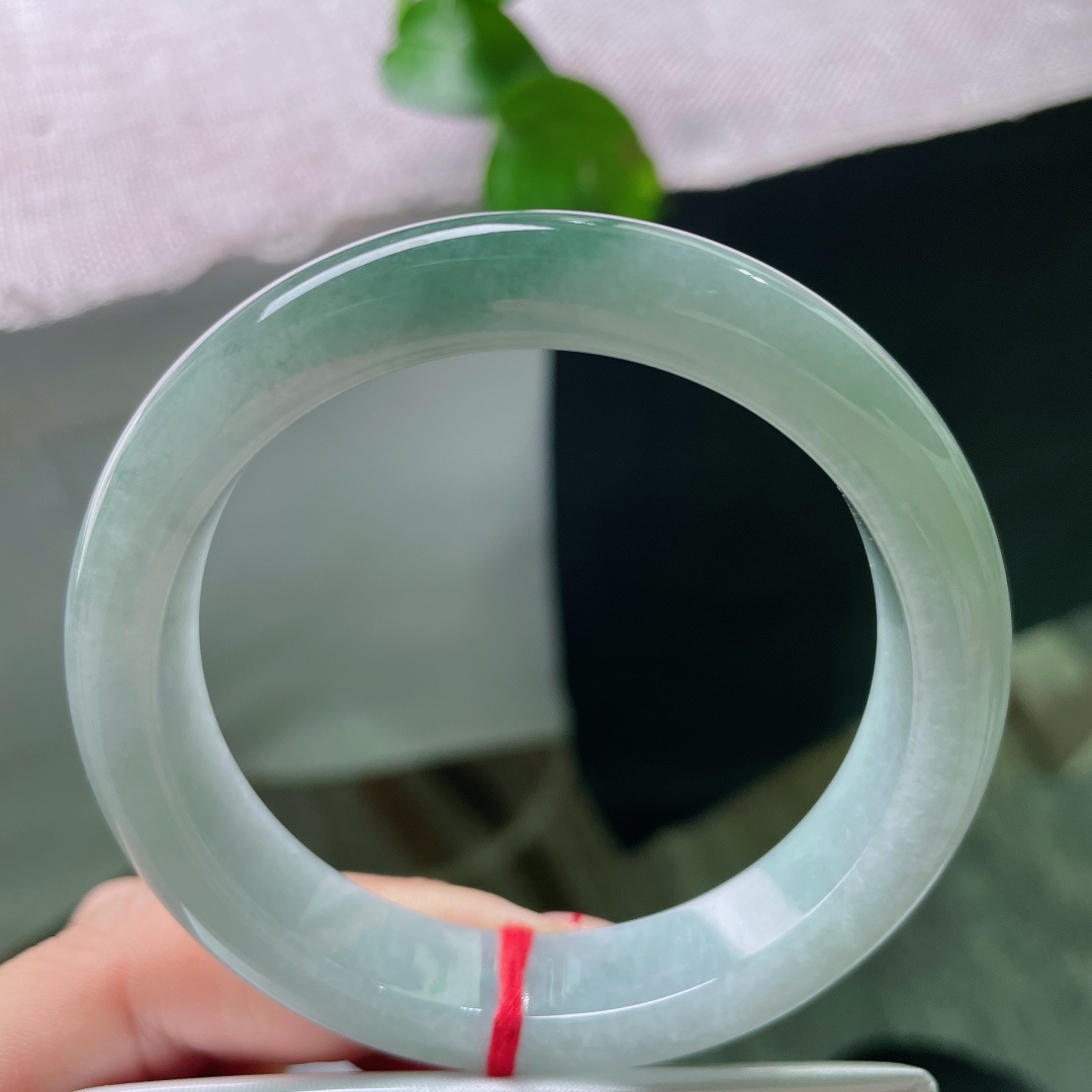 蓝底飘色正圈，底色清透柔和，镯身晕开一抹油绿色，温润动人。腕间轻绕，藏着清简治愈的东方温柔。无裂，s
