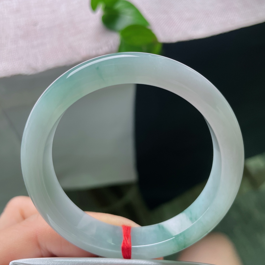 53.7/11.5/8.3，飘花正圈，有裂，质地细腻莹润，几缕灵动的飘绿丝丝萦绕镯身，增添了飘逸气韵