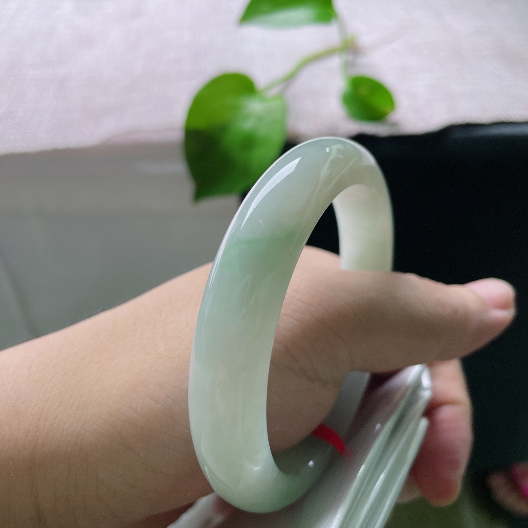 56.8/12.4/9.1，飘花正圈，横裂，底色莹白温润，几缕淡翠如烟似雾般晕染在玉身两侧，清浅灵动。ss55795a