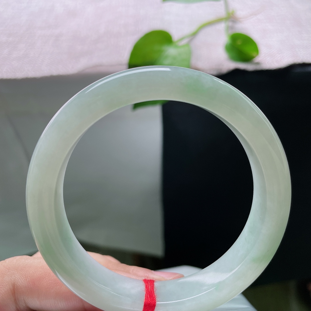 56.8/12.4/9.1，飘花正圈，横裂，底色莹白温润，几缕淡翠如烟似雾般晕染在玉身两侧，清浅灵动