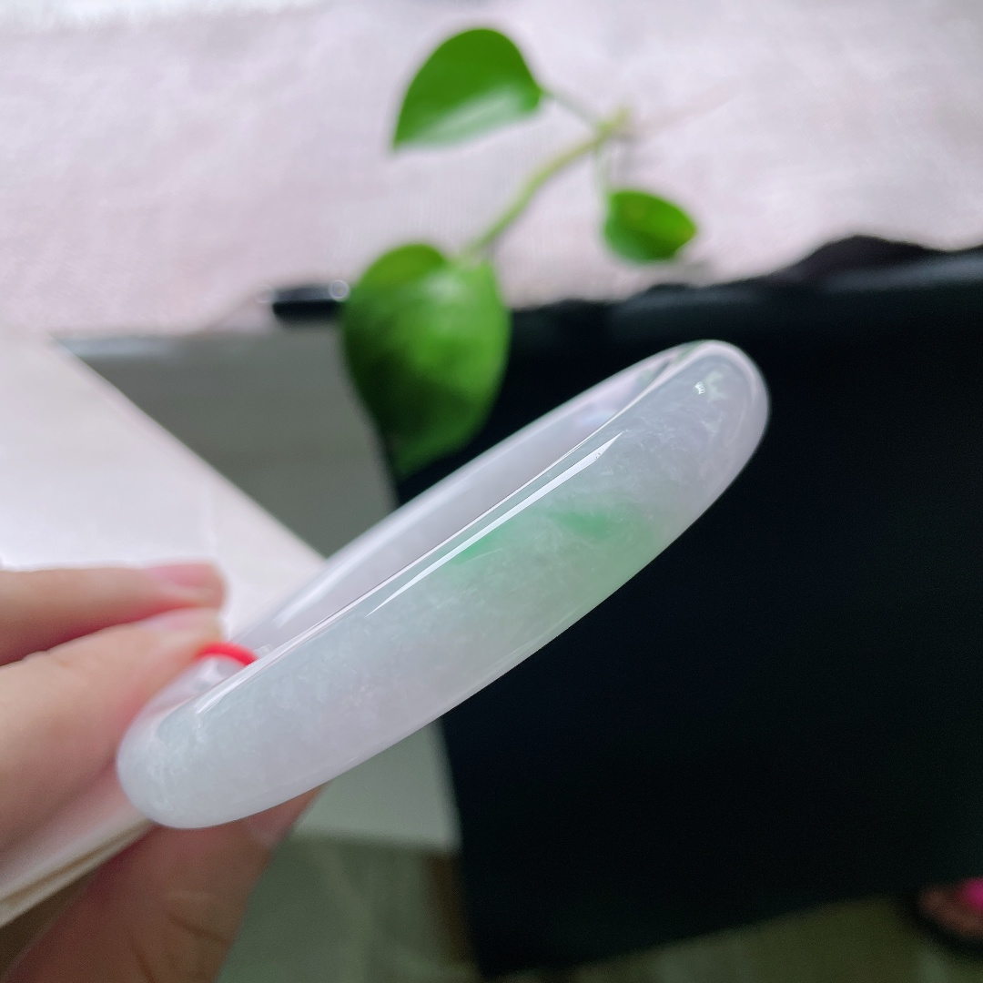 56.8/11.3，春带彩圆条，无裂，饱满圆润的镯身自带古典韵味，镯底俏生一抹鲜亮阳绿，温润柔和，紫底衬翠色，一紫一绿相映成趣。ss55697a