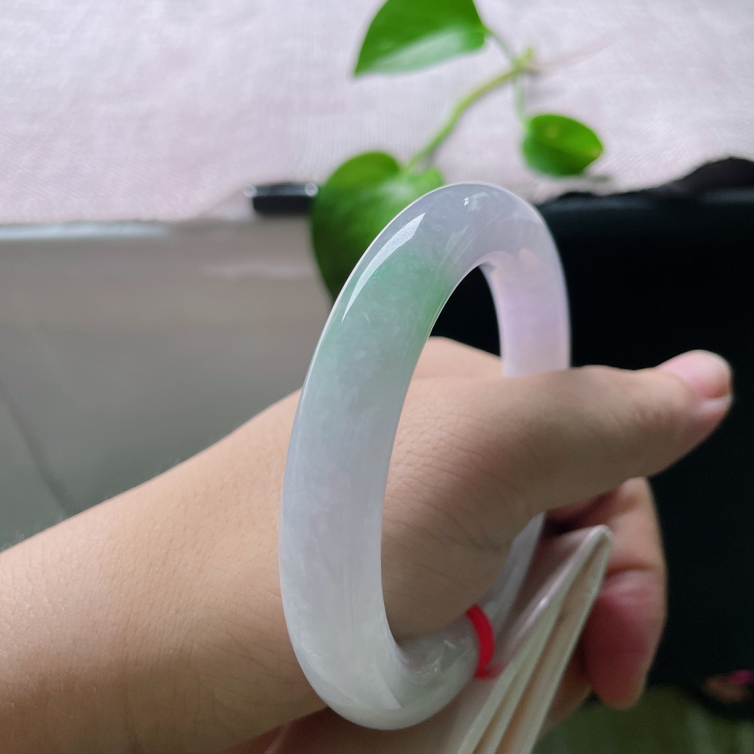 56.8/11.3，春带彩圆条，无裂，饱满圆润的镯身自带古典韵味，镯底俏生一抹鲜亮阳绿，温润柔和，紫底衬翠色，一紫一绿相映成趣。ss55697a