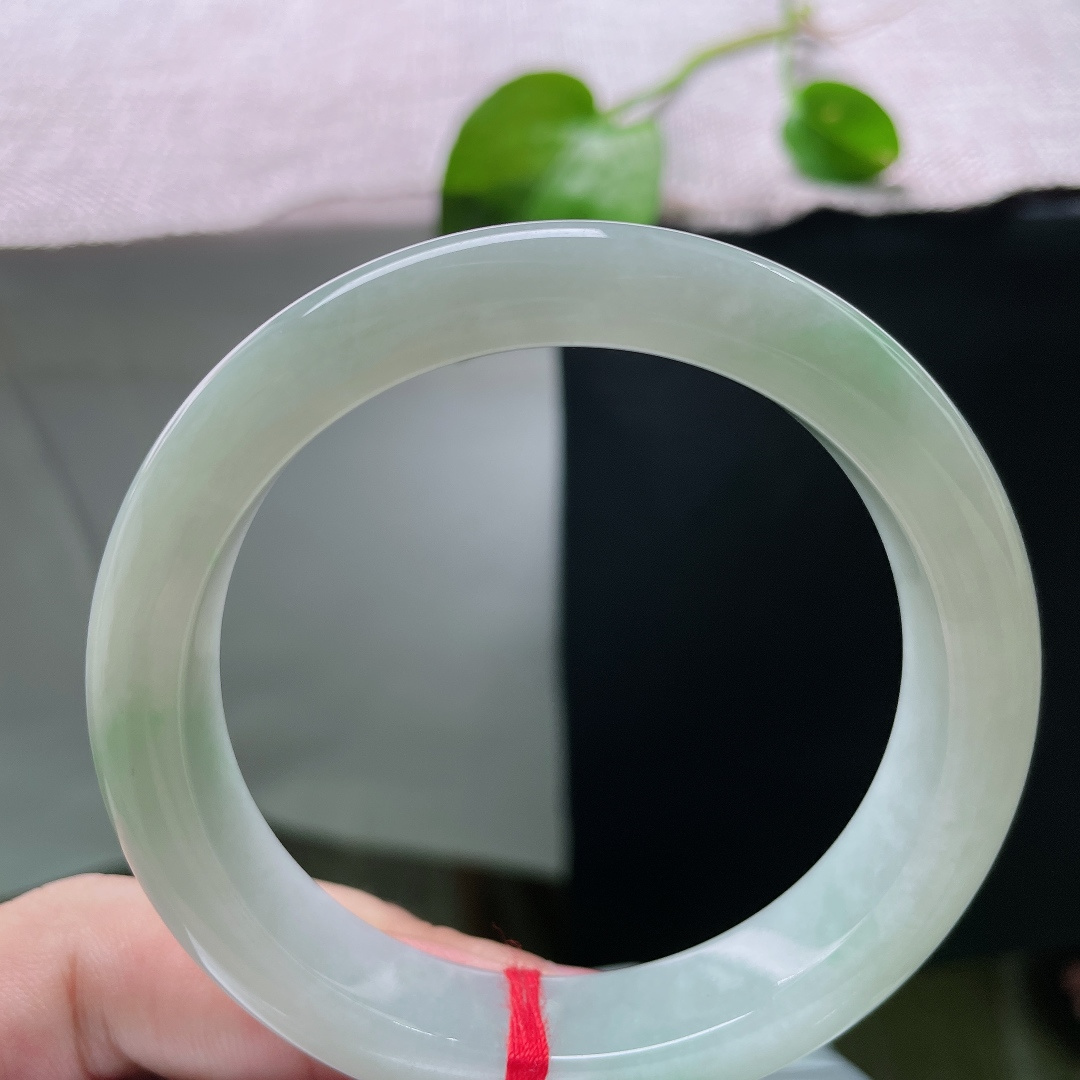 56.8/12.4/9.1，飘花正圈，横裂，底色莹白温润，几缕淡翠如烟似雾般晕染在玉身两侧，清浅灵动。ss55795a