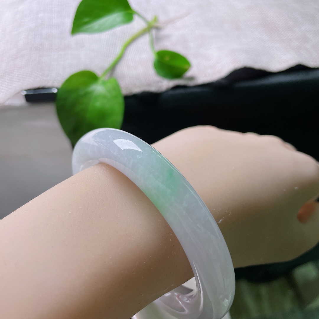 56.8/11.3，春带彩圆条，无裂，饱满圆润的镯身自带古典韵味，镯底俏生一抹鲜亮阳绿，温润柔和，紫底衬翠色，一紫一绿相映成趣。ss55697a