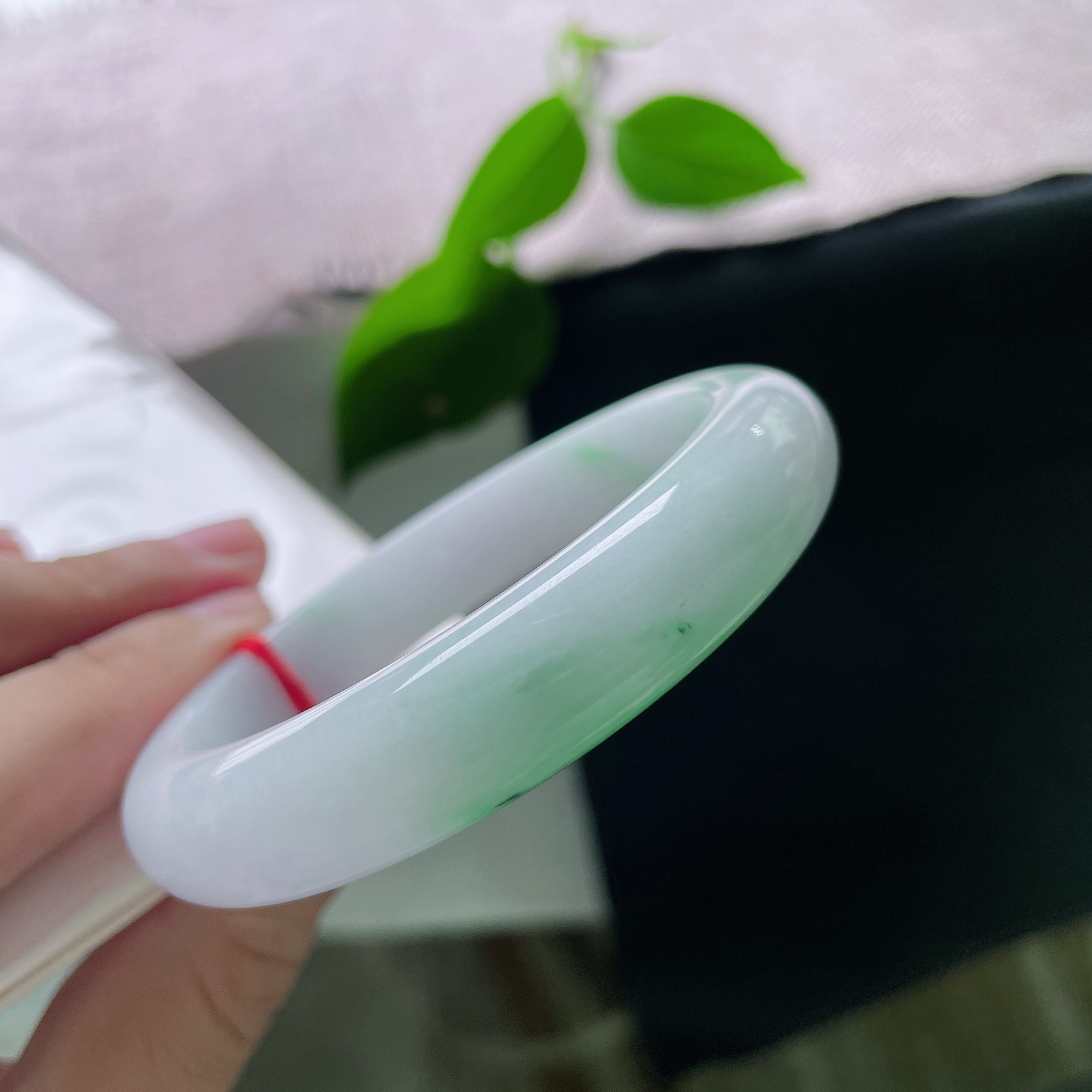 58.5/12.6/8.8，白底青正圈，棉线，玉底温润细腻，一截鲜活翠色自镯底缓缓晕染铺开，浓艳自然，似春日新芽落于素玉之上，ss56457a