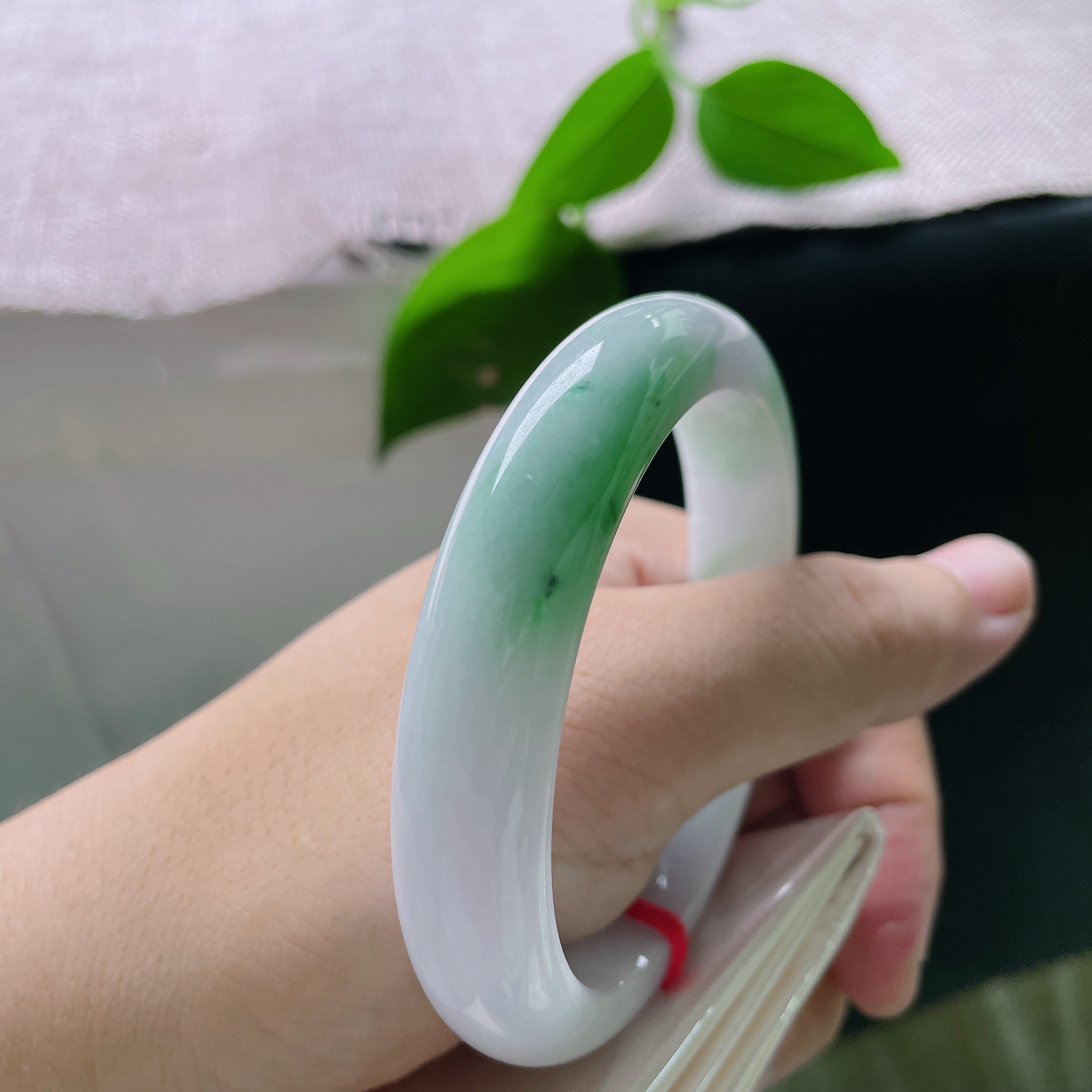58.5/12.6/8.8，白底青正圈，棉线，玉底温润细腻，一截鲜活翠色自镯底缓缓晕染铺开，浓艳自然，似春日新芽落于素玉之上，ss56457a
