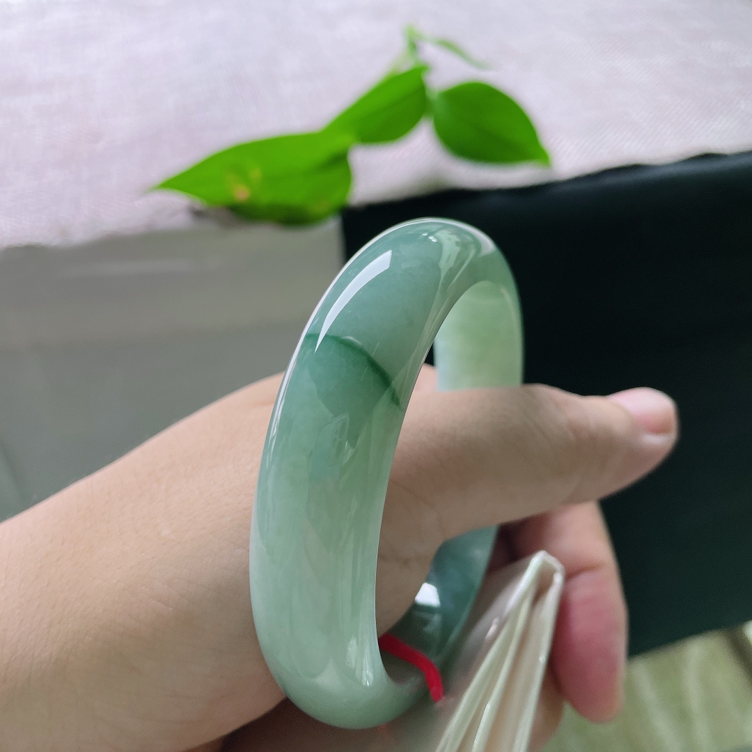 飘花正圈，无裂，一镯浸青水，微光藏玉间。沉静油青底色温润内敛，细缕翠色轻缀镯身，腕间自带低调雅致的韵味。ss56475a
