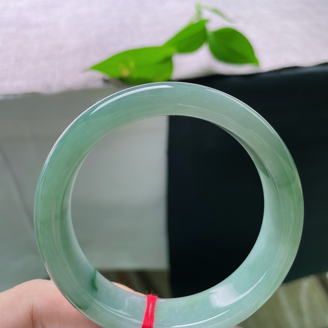 飘花正圈，无裂，一镯浸青水，微光藏玉间。沉静油青底色温润内敛，细缕翠色轻缀镯身，腕间自带低调雅致的韵味。ss56475a
