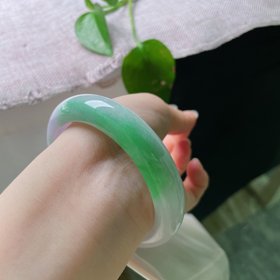 54.8/12.5/8.6，春彩正圈，无裂，淡紫为底，翠色流光，一抹鲜绿悄然铺展镯身。紫与翠天然相映，盈盈一镯，将春日色彩凝于腕间。ss56453a