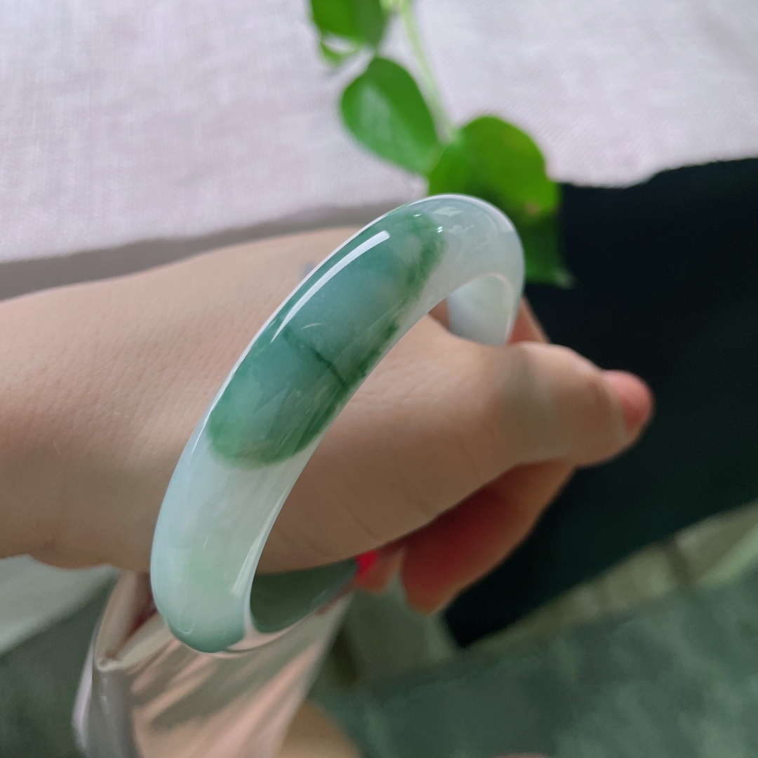 55.2/12/8.3，飘花正圈，无裂，晴玉含清光，翠色卧镯边。淡雅底色衬一抹绿意，清风入腕，温润自在。ss56467a