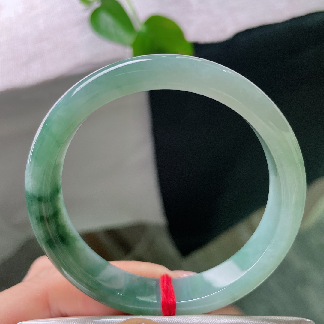 56/12.1/7.7，飘花正圈，无裂，油青飘花正装手镯，由浅至深渐变湖水绿，下半段浓墨飘花自然晕染，层次感十足。ss56473a