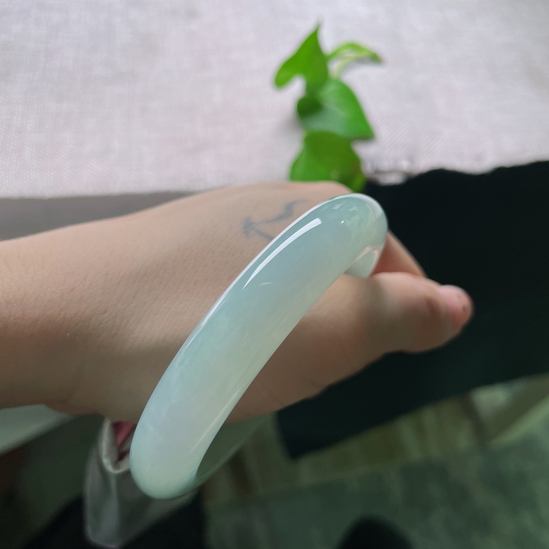 57/12.3/8.9，绿底正圈，无裂，浅青晴水凝玉镯，质地水润澄澈，素面简约温润大方，腕间一抹淡雅清光，把温柔与静谧悄然收纳。ss55819a