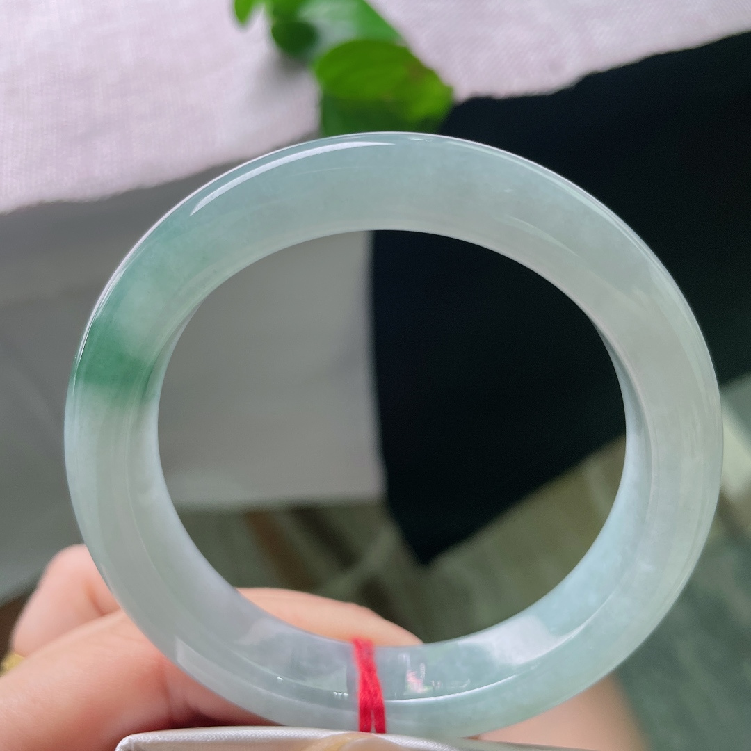 57.7/12.8/9.4，飘花正圈，无裂，素玉藏着一汪清浅冰湖，一缕翠意静卧镯底，似远山含黛，玉面莹亮温润。无繁复纹饰，安静柔和，是独属于中式的内敛温柔。ss54291a