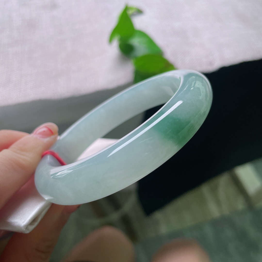 57.7/12.8/9.4，飘花正圈，无裂，素玉藏着一汪清浅冰湖，一缕翠意静卧镯底，似远山含黛，玉面莹亮温润。无繁复纹饰，安静柔和，是独属于中式的内敛温柔。ss54291a