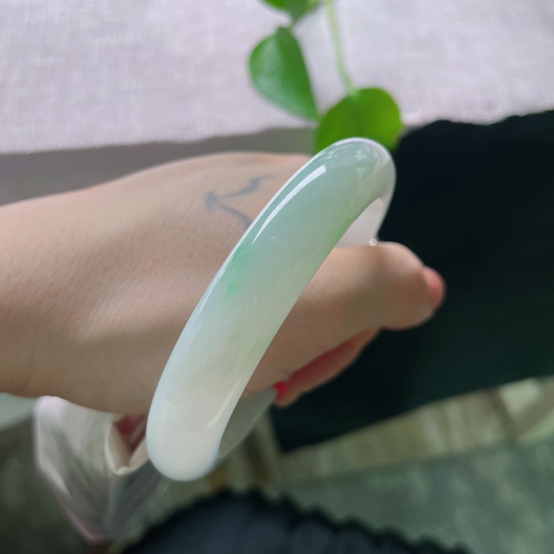 56.8/11.3/7.9，飘绿正圈，无裂，冰底清透如玉，一抹浅翠静落镯底，似远山浮于薄雾之间，清素柔和，自带静谧空灵的气韵。ss56943a